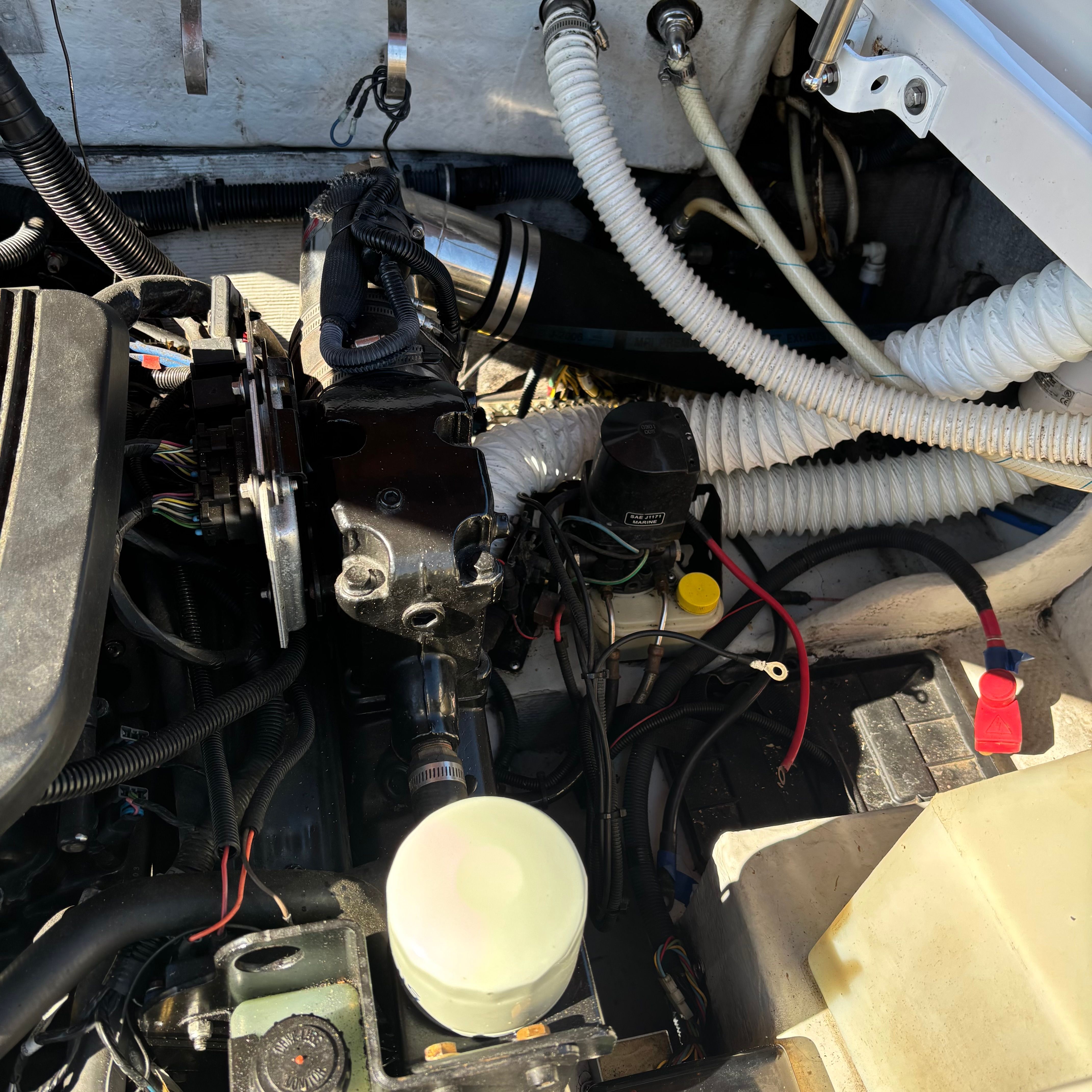 Engine compartment of a 2003 Chris-Craft Launch 22 with visible hoses and wires.