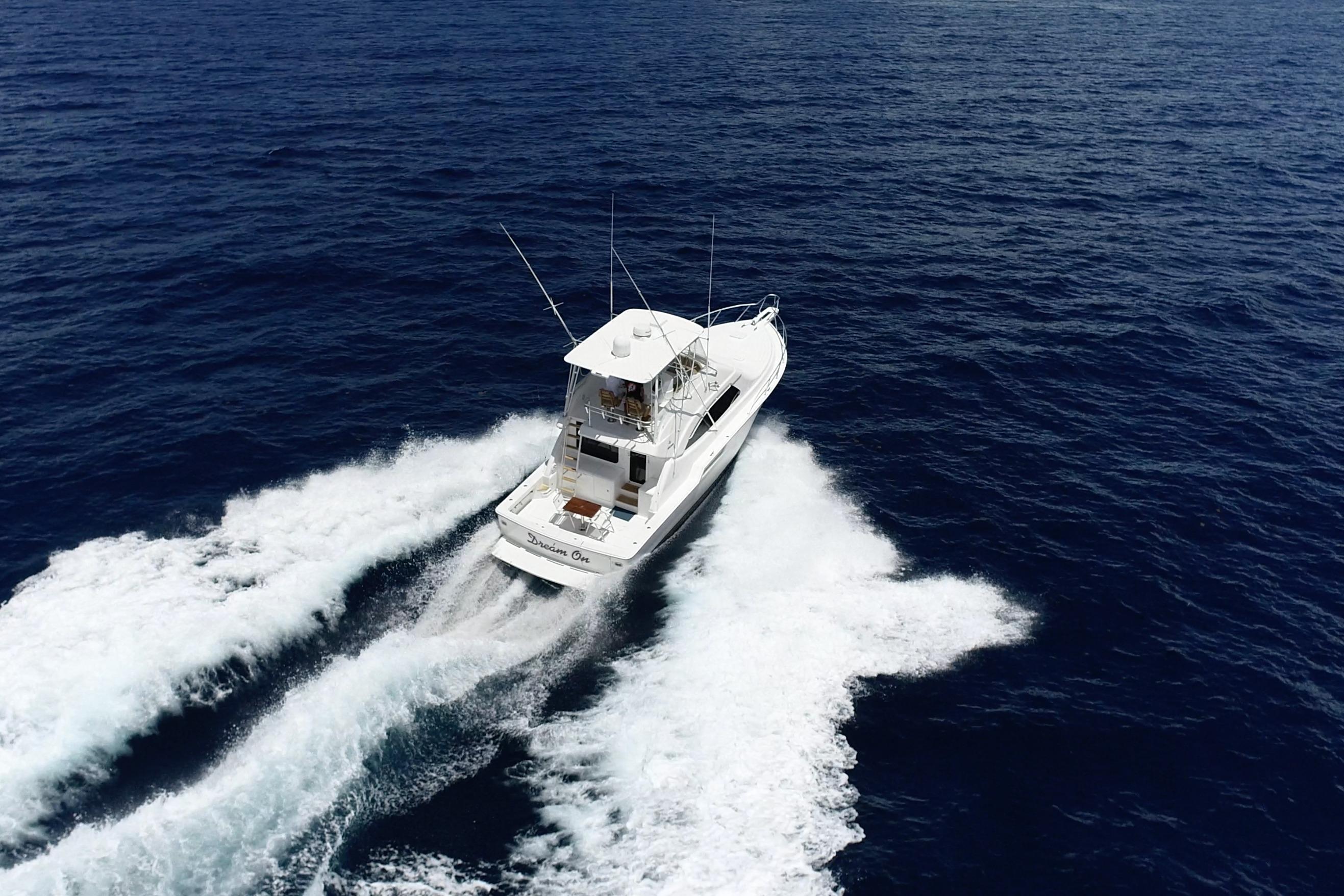 Aerial view of 2005 Bertram 450 yacht cruising on open ocean waters.
