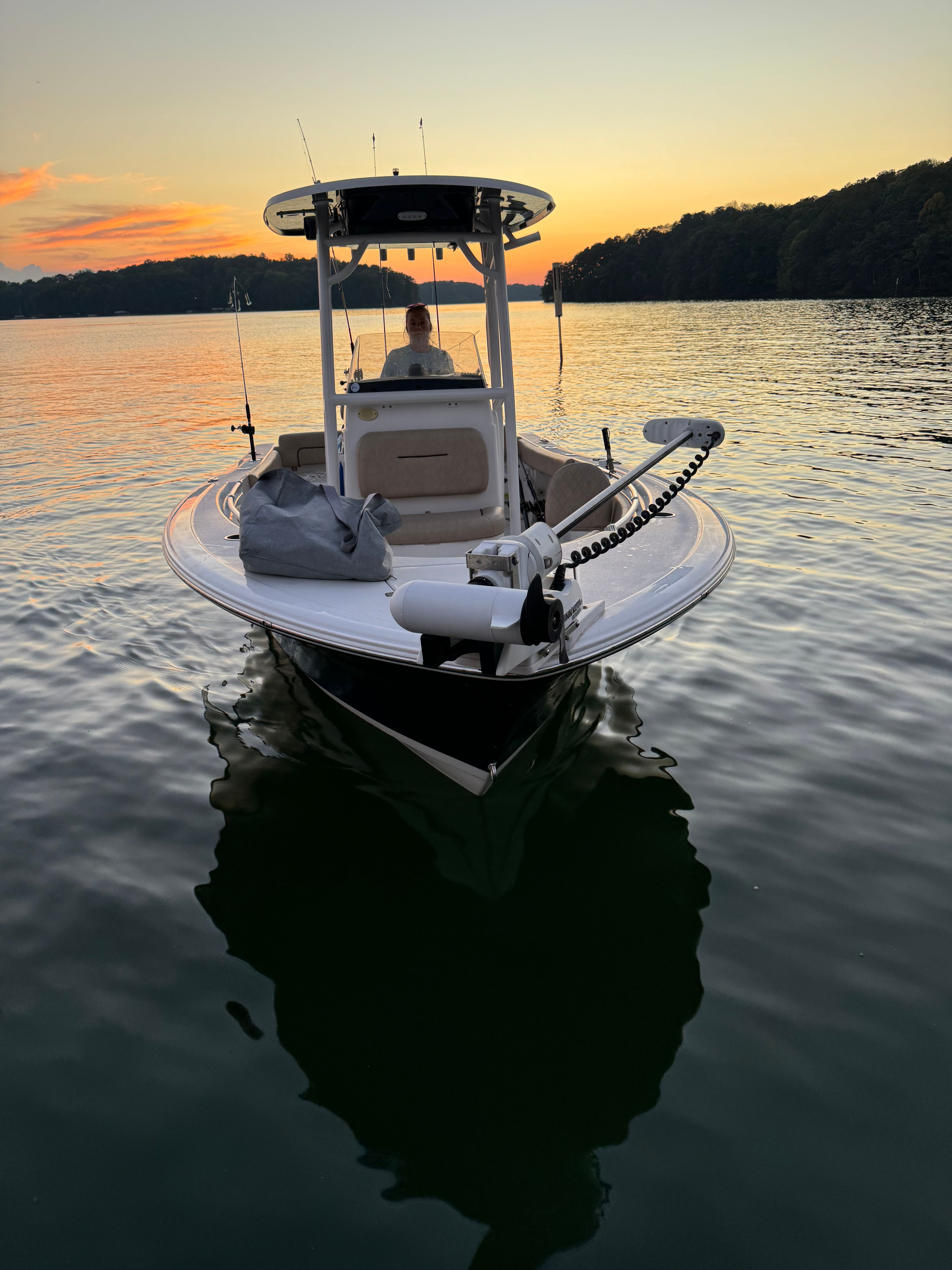A 2020 Sportsman Heritage 211 Center Console boat on calm water at sunset.