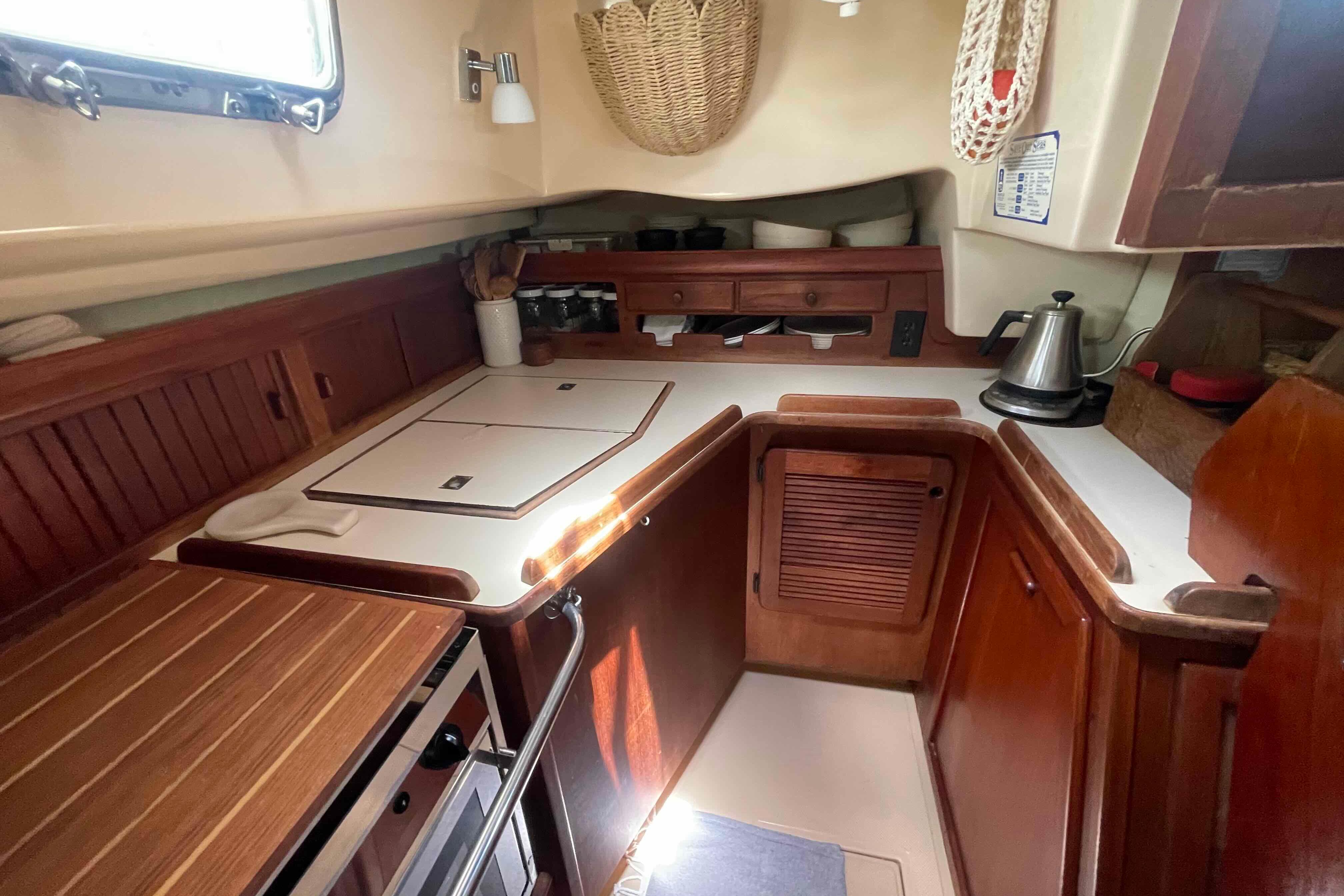 1989 Island Packet 35 yacht kitchen with wooden cabinetry and modern appliances.