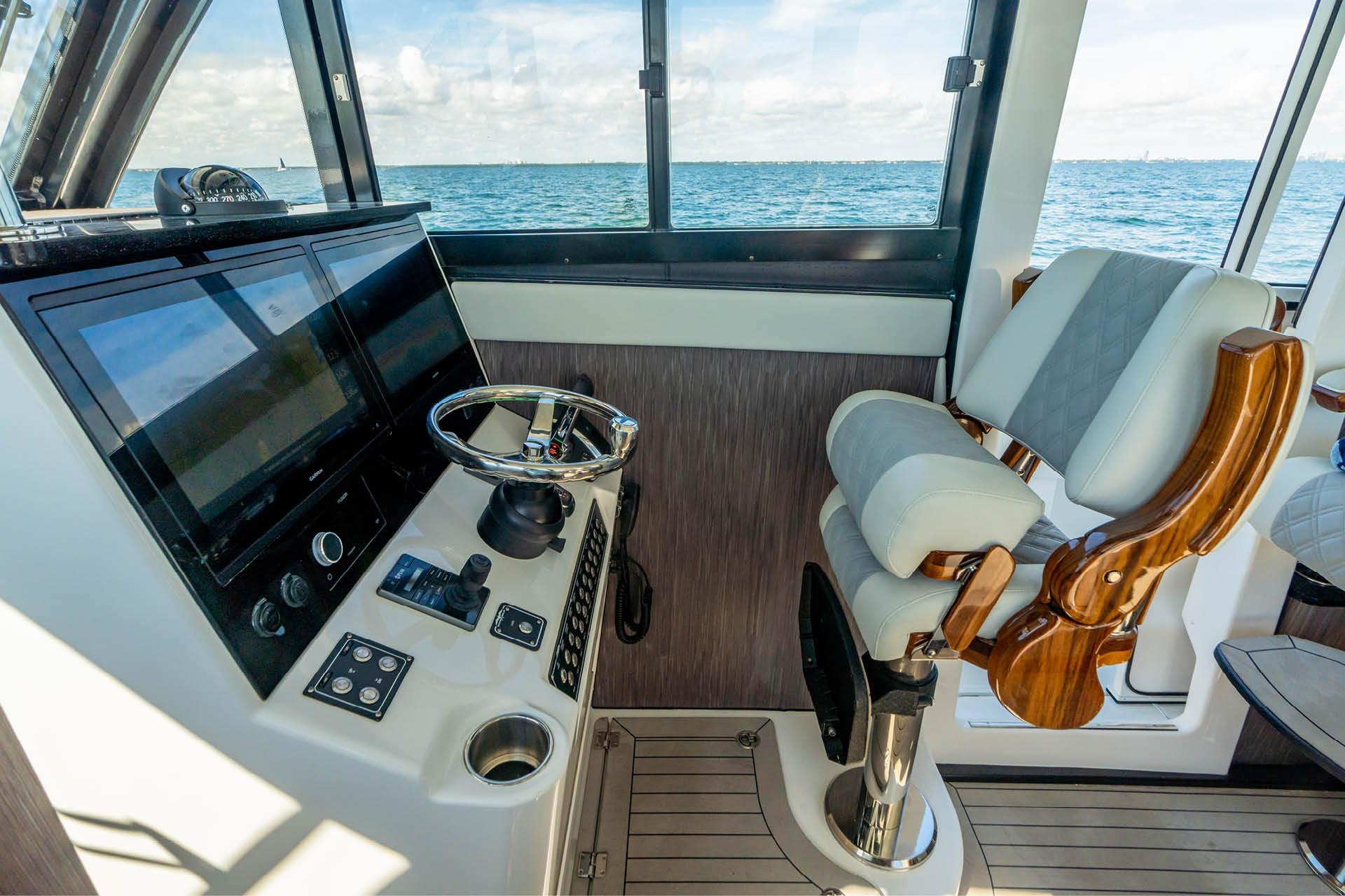 Pilothouse interior of 2026 Invincible 46, featuring modern controls and luxurious seating.