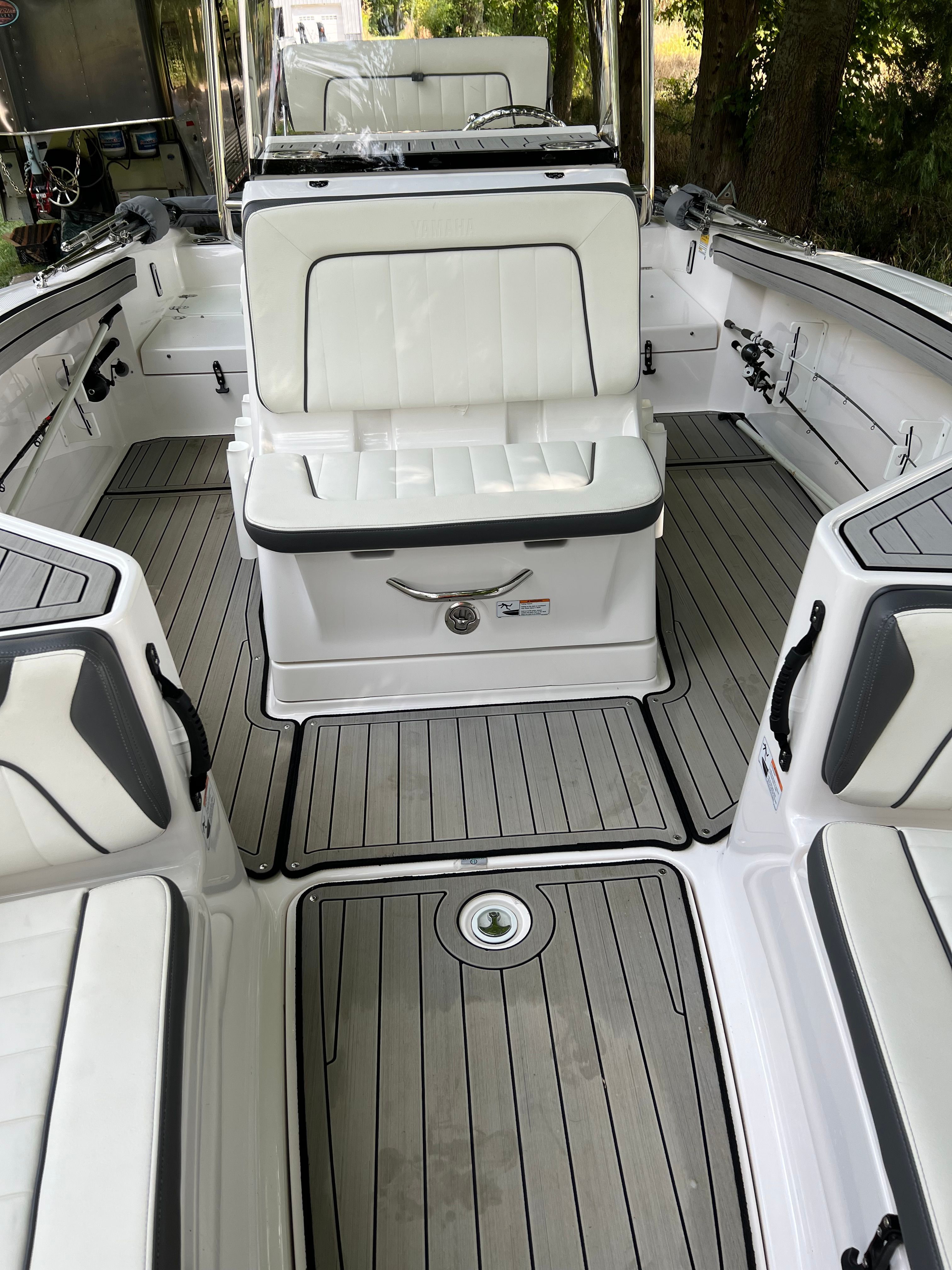 Interior of 2022 Yamaha Boats 210 FSH Deluxe with gray flooring.