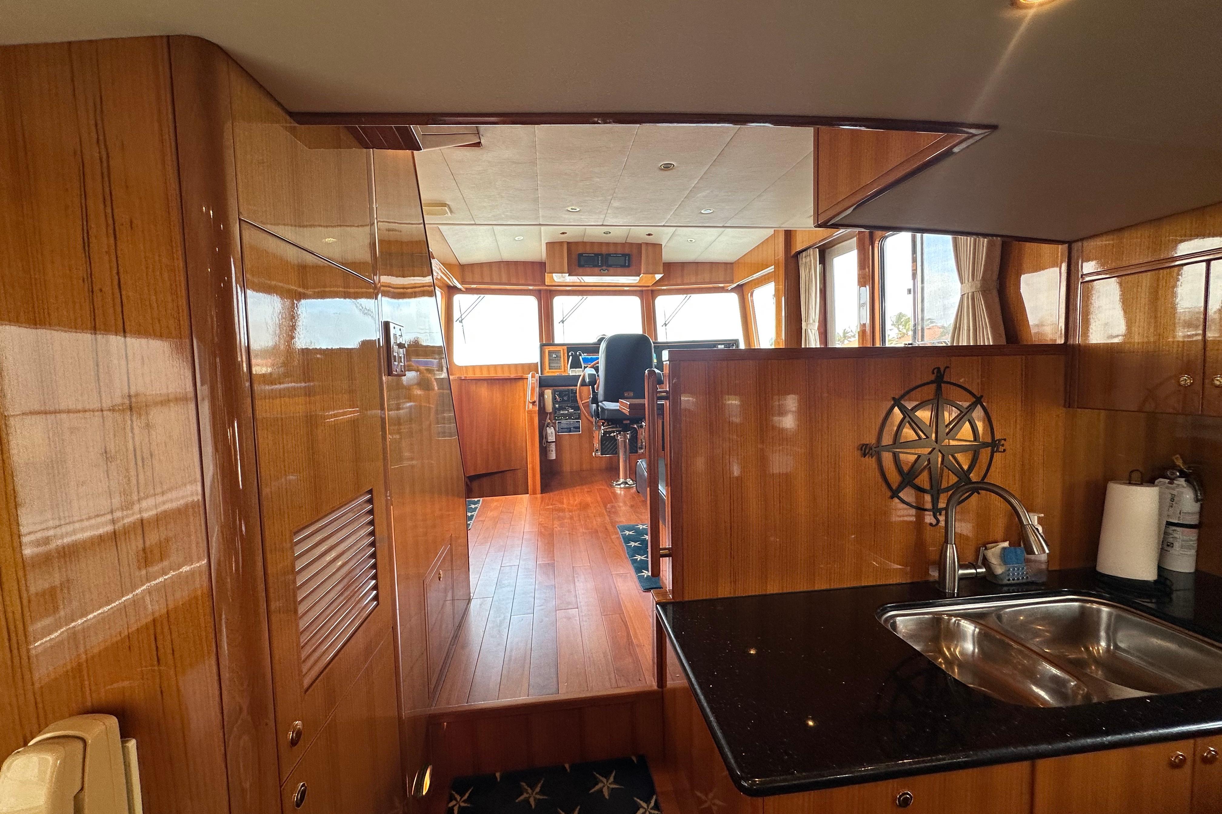 Luxurious interior of 2005 Jefferson Pilothouse 63 yacht with polished wood and modern amenities.