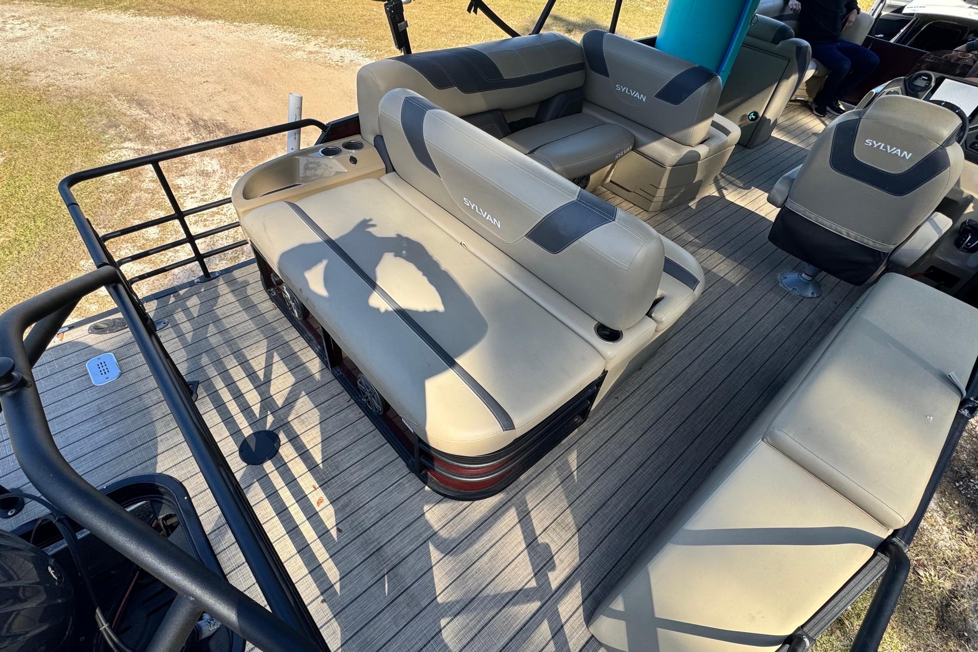 2023 Sylvan L5 CLZ pontoon boat interior with beige seating and wood-style flooring.