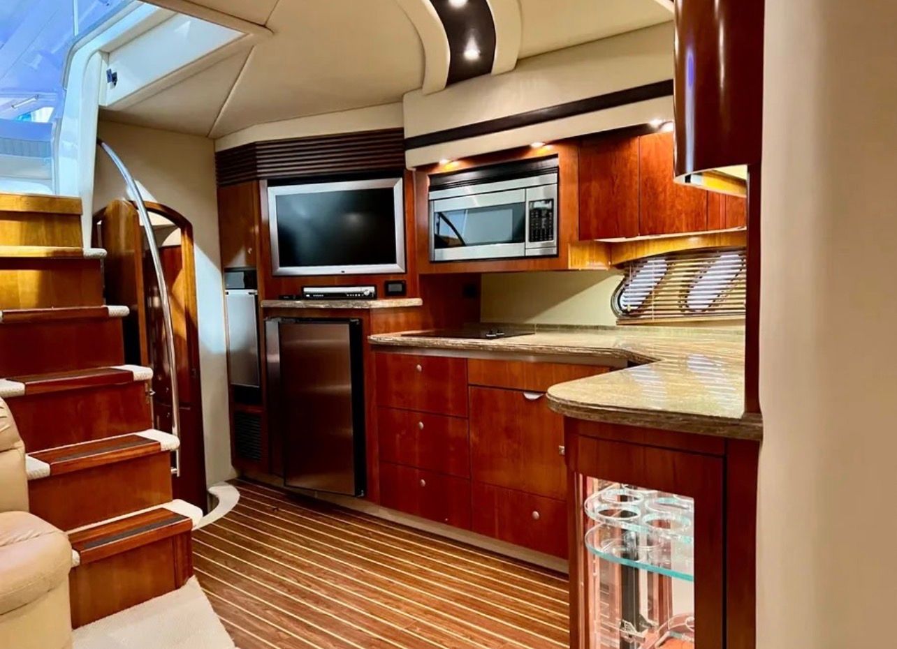 Interior of the 2009 Cruisers Yachts 520 Sports Coupe with sleek kitchen and wood paneling.