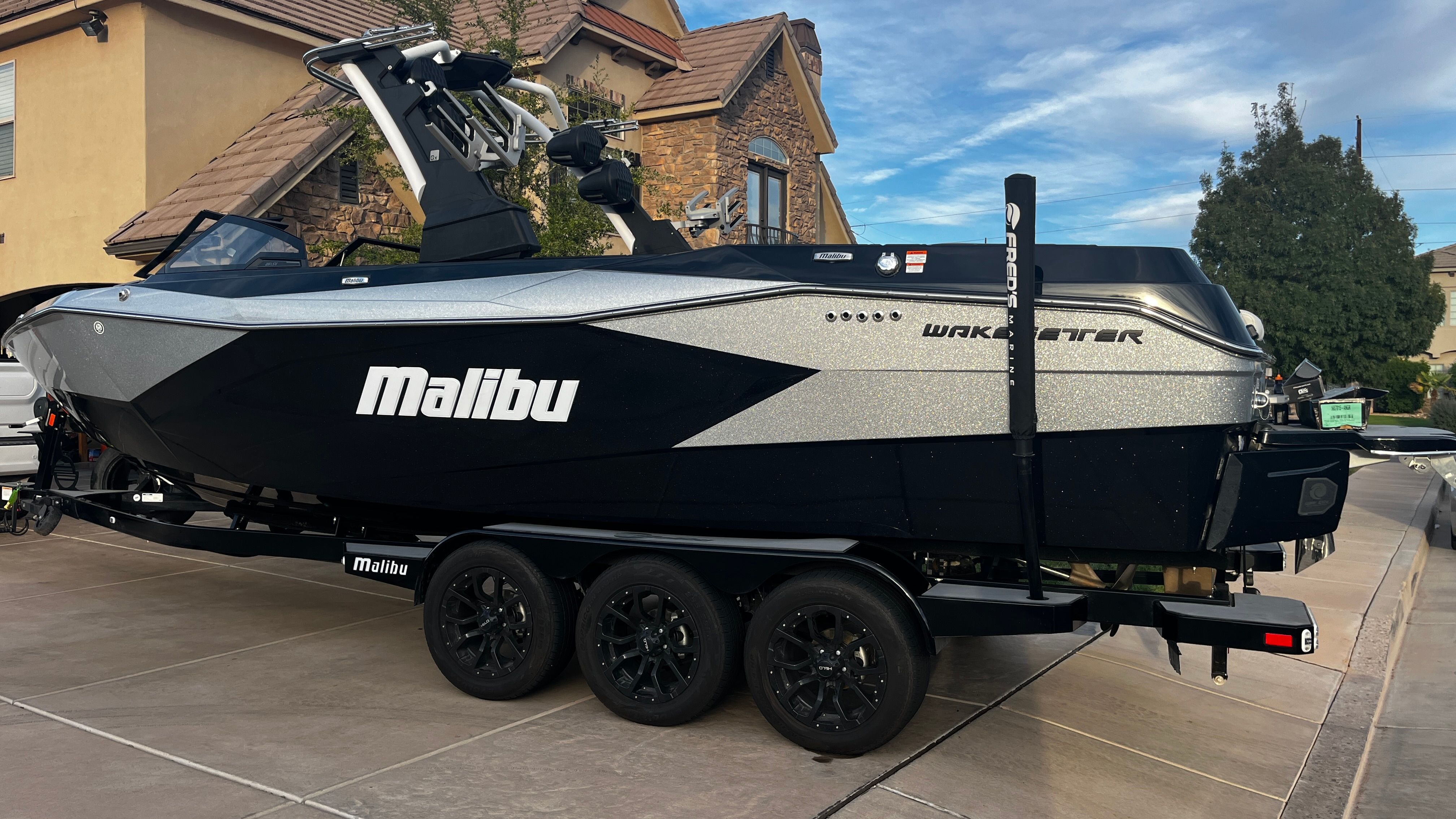 2023 Malibu Wakesetter 26 LSV on a trailer in a driveway.