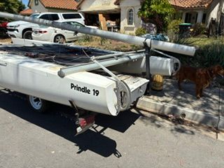 A Prindle 19 catamaran parked on a trailer in a residential street.