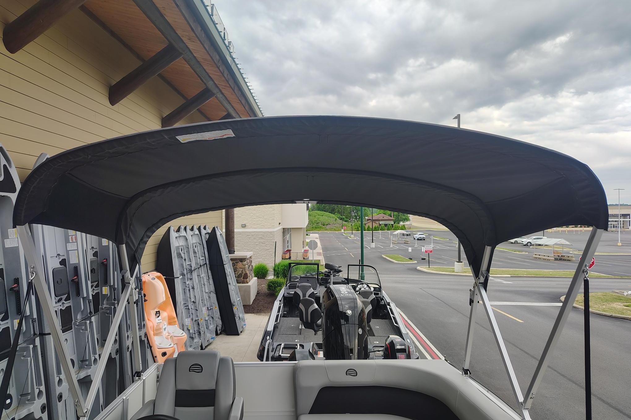 2026 Sun Tracker Party Barge 16 DLX pontoon boat with canopy in parking lot.