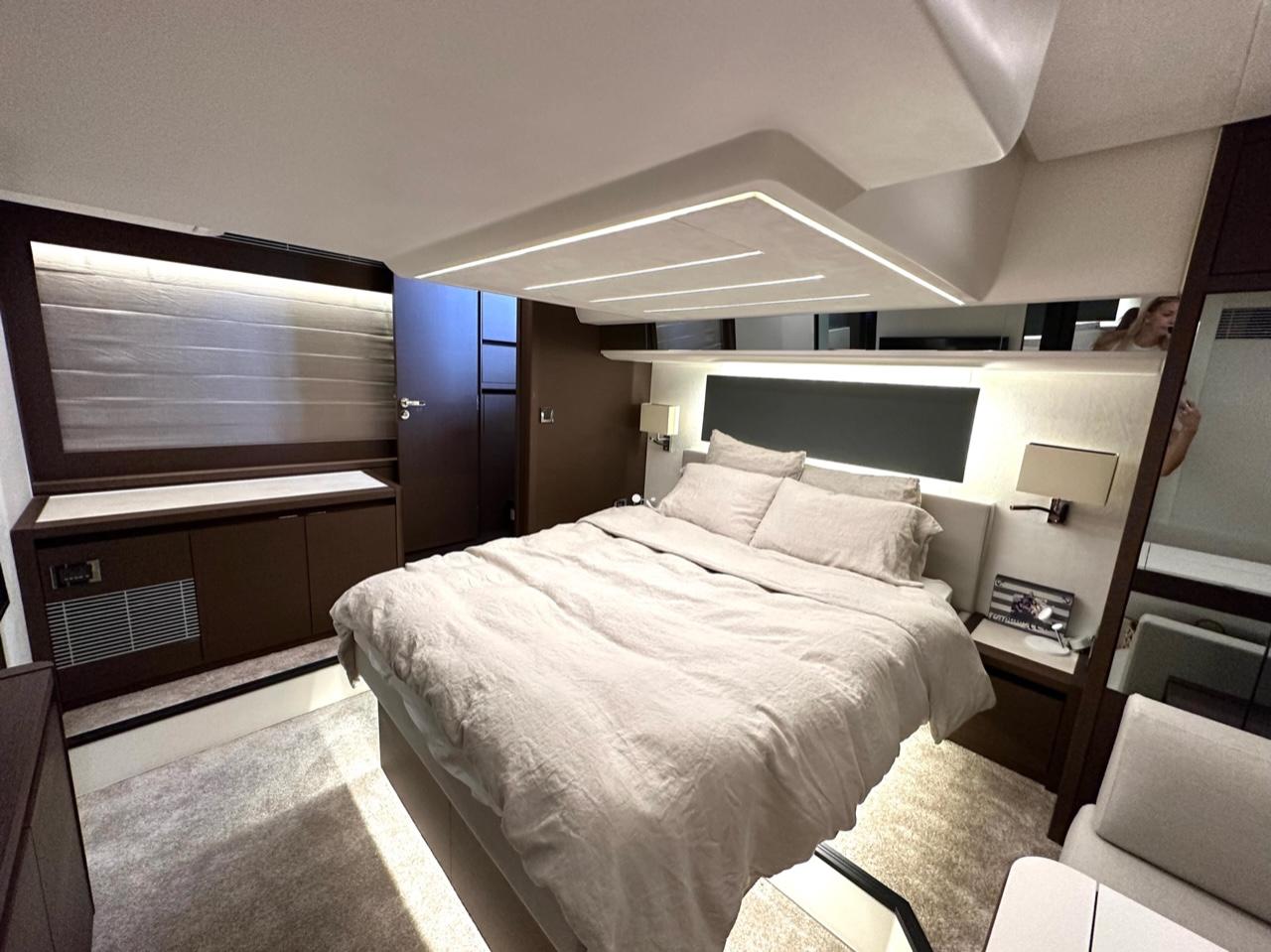 Luxurious bedroom interior of 2021 Prestige 590 Sport Fly yacht, featuring modern design and cozy bedding.