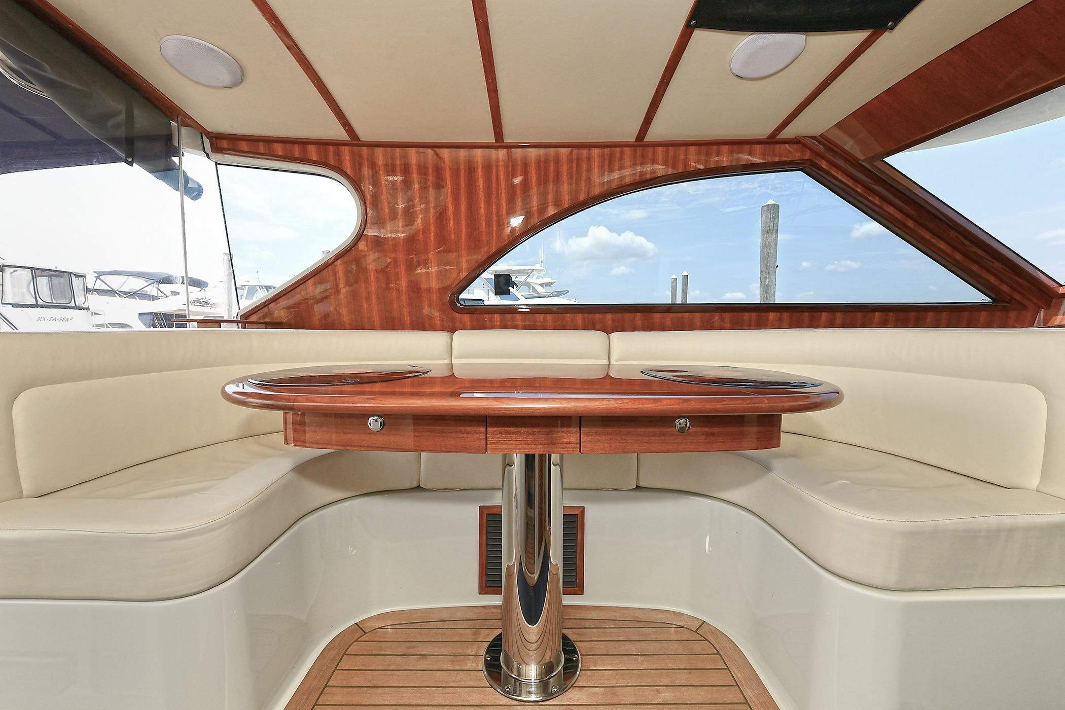 Luxurious interior of 2005 San Juan Downeast Express yacht with elegant wood and leather seating.