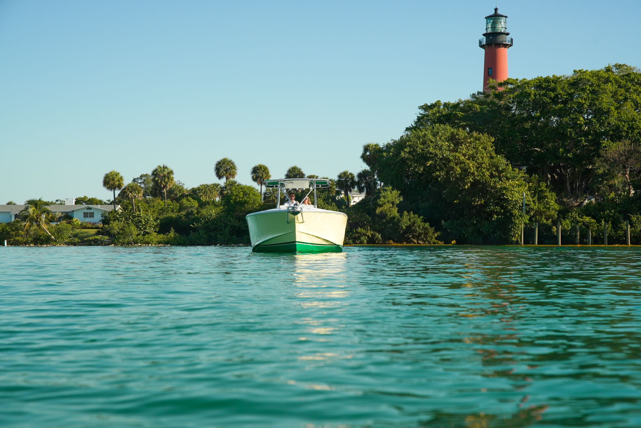 Ocean Master 28 boat near lighthouse and palm trees, 1985 model.