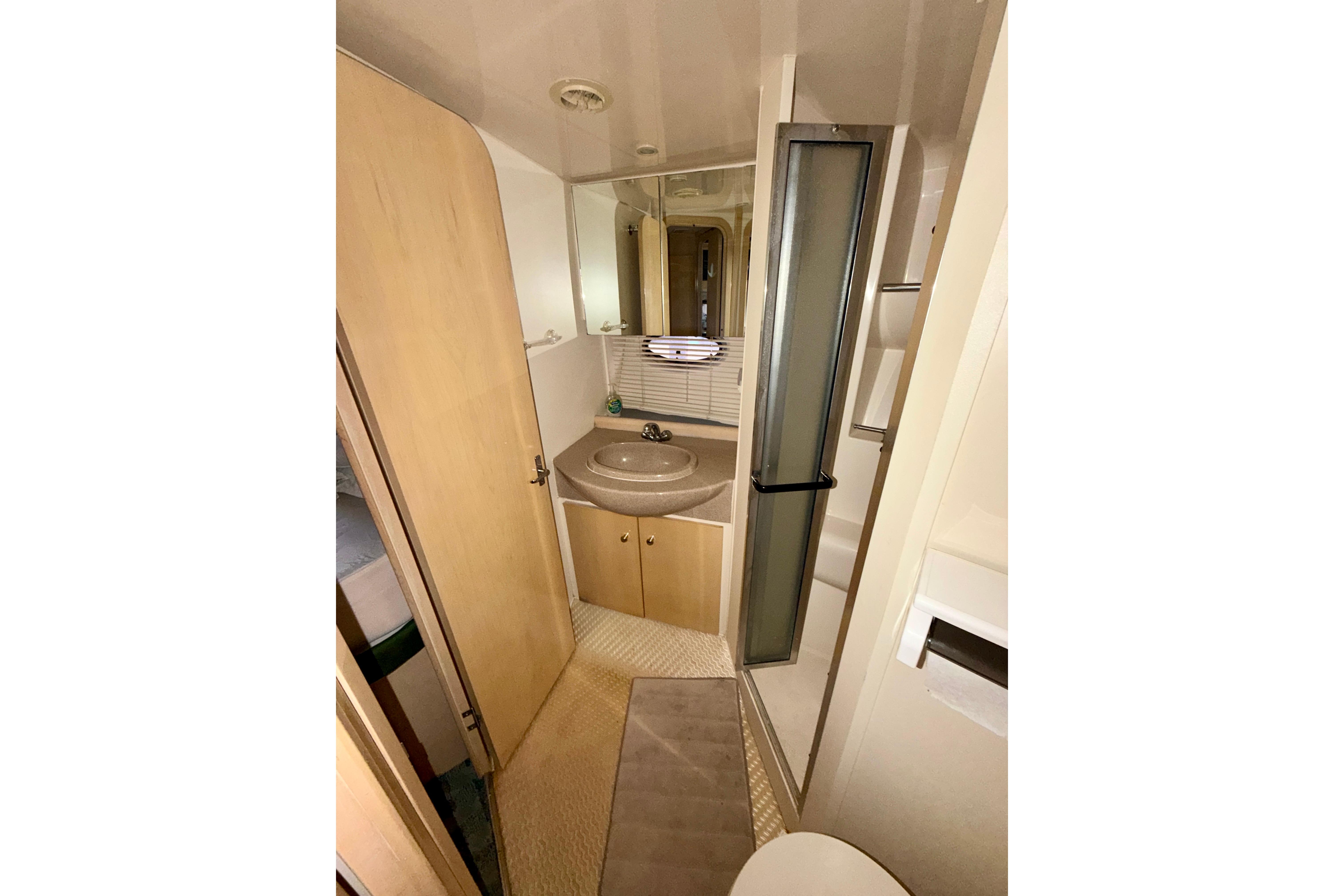 Bathroom interior of 2000 Carver 350 Mariner yacht with sink and shower.