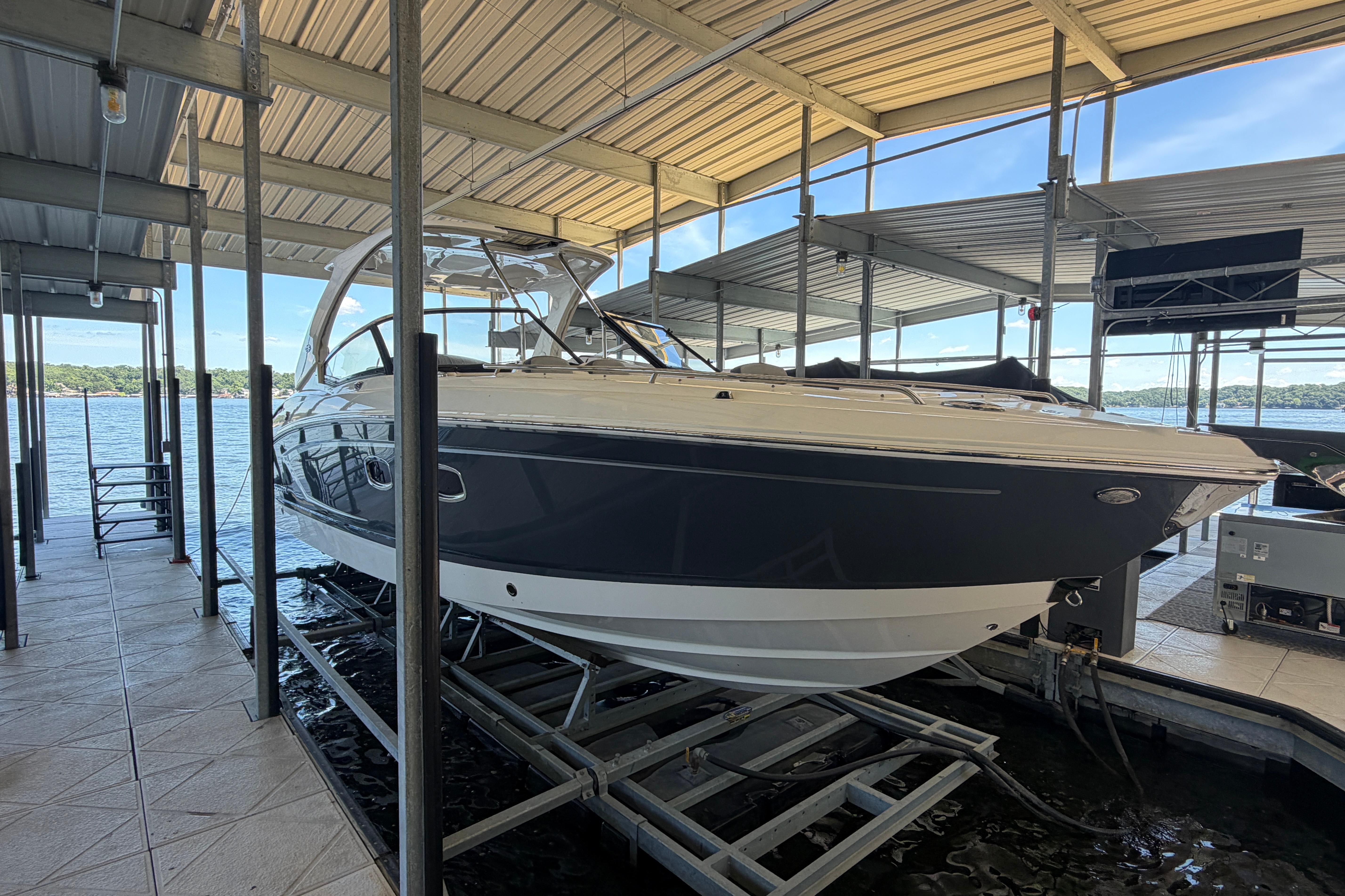 2018 Chaparral 347 SSX boat docked in a covered marina with scenic lake view.