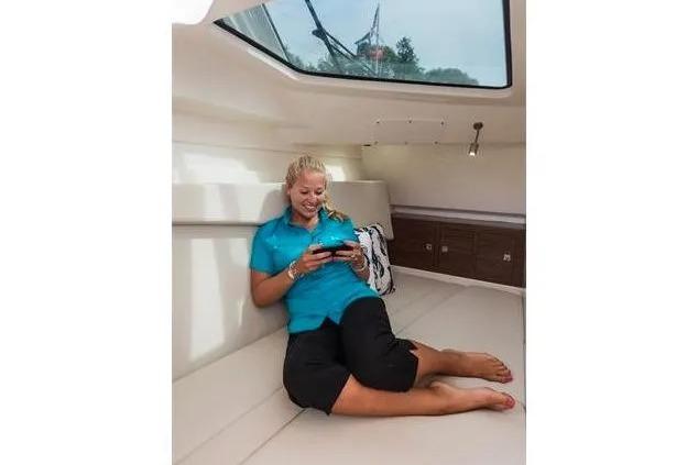 Woman relaxing inside a 2017 Boston Whaler 320 Vantage boat cabin.