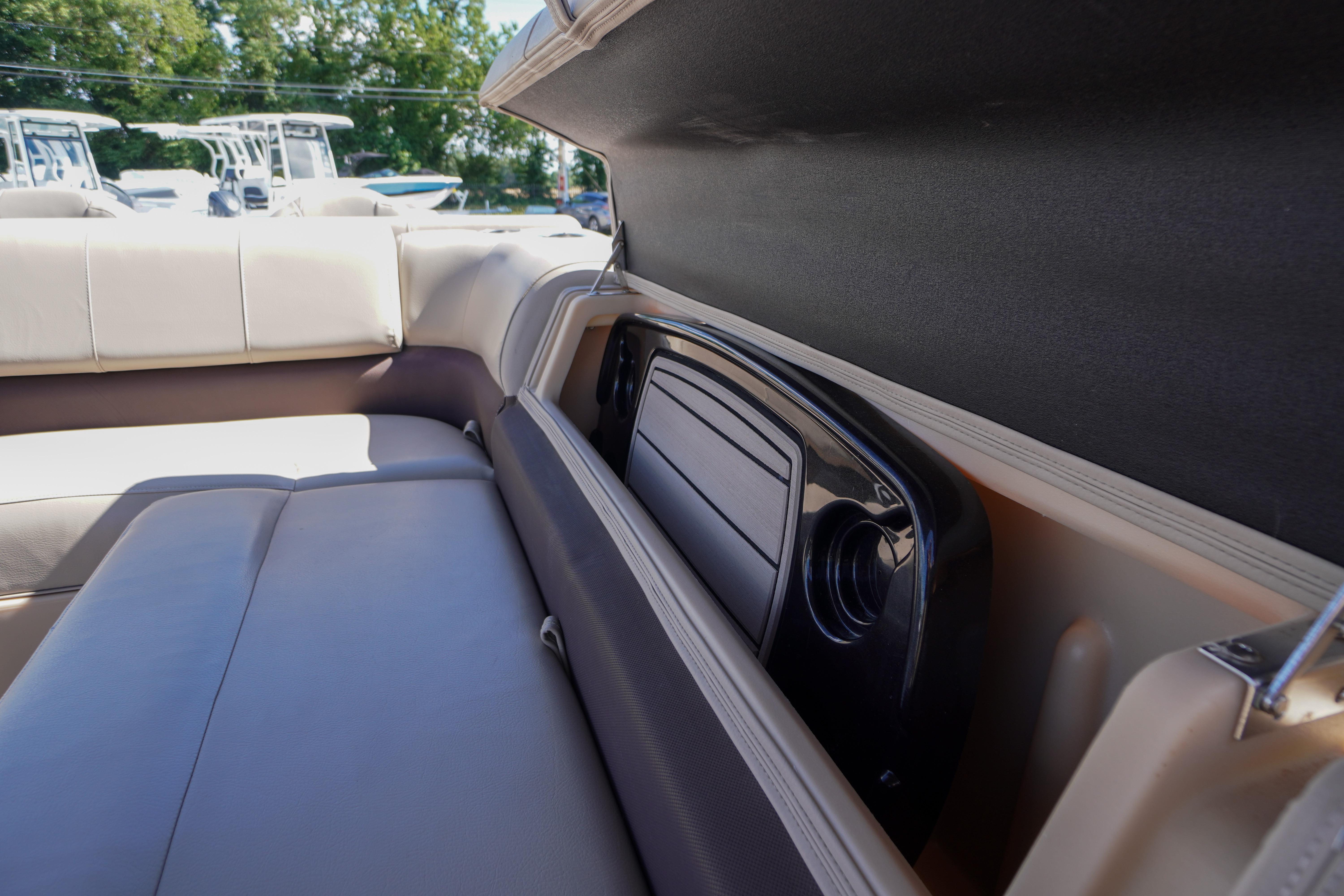 2019 SUNTRACKER Fishin' Barge 22 DLX boat interior storage compartment with cushioned seating.