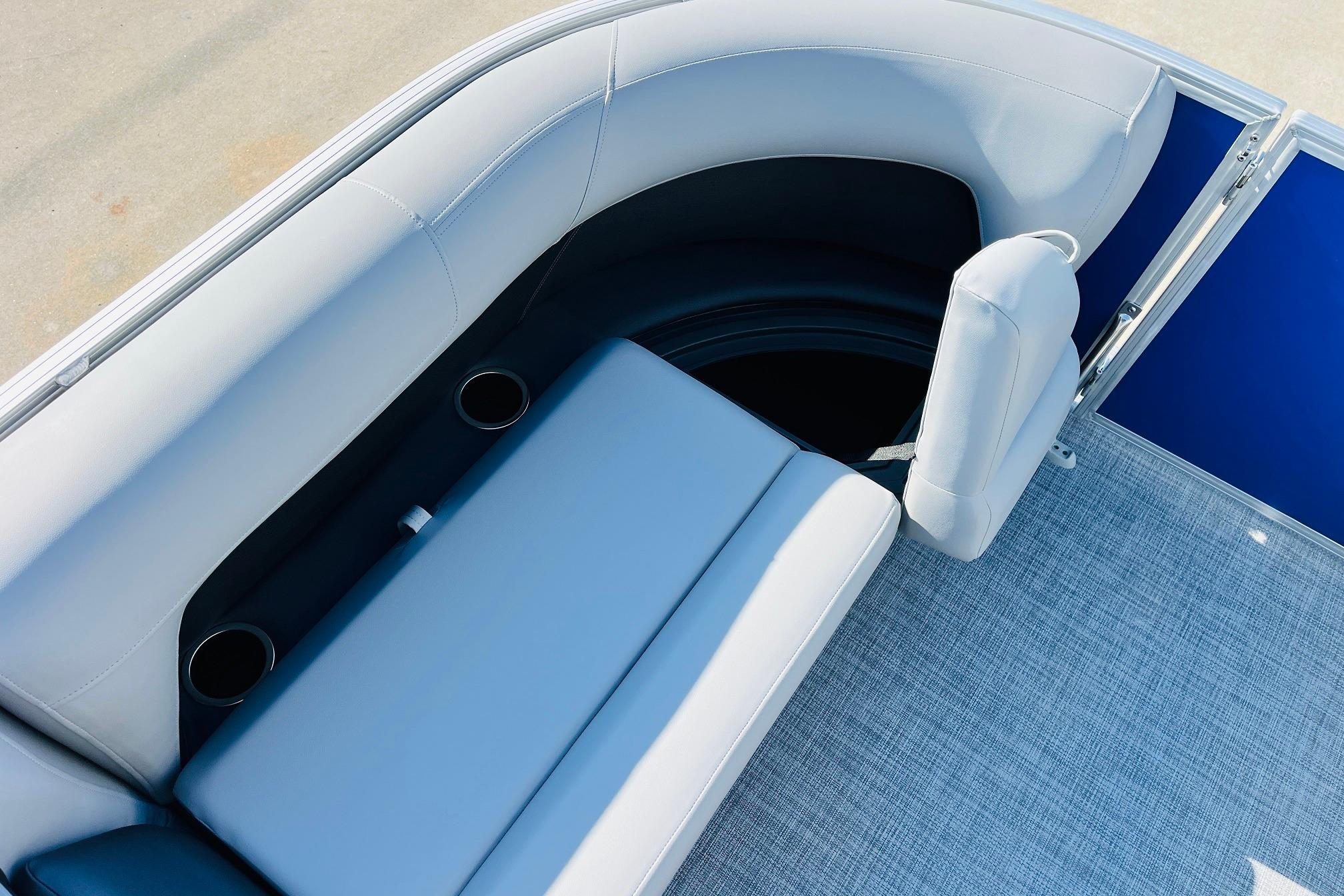 2026 Sun Tracker Party Barge 18 DLX interior seating with cup holders and blue accents.