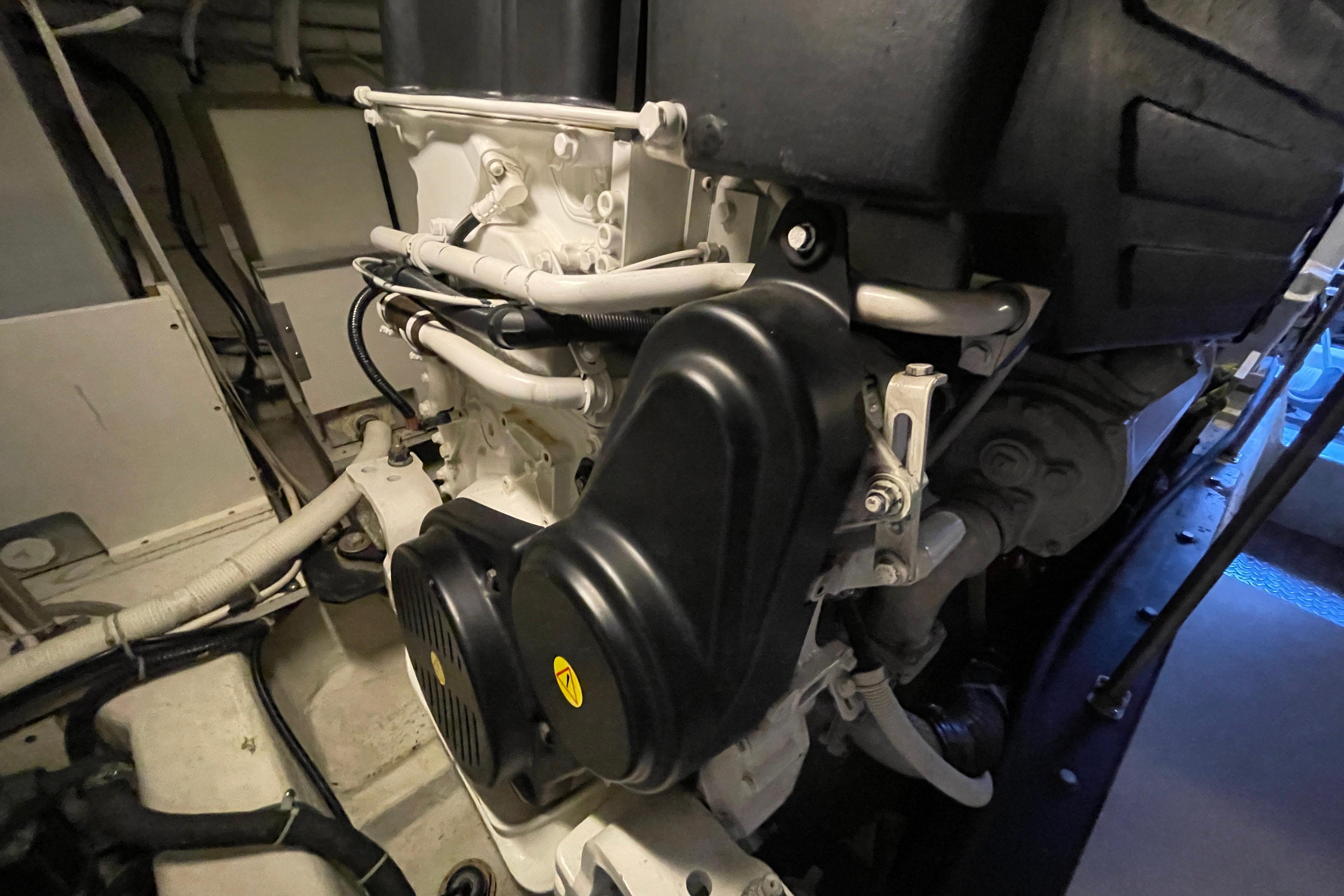 Engine room of 2002 Carver 570 Voyager Pilothouse, showcasing mechanical components and piping.