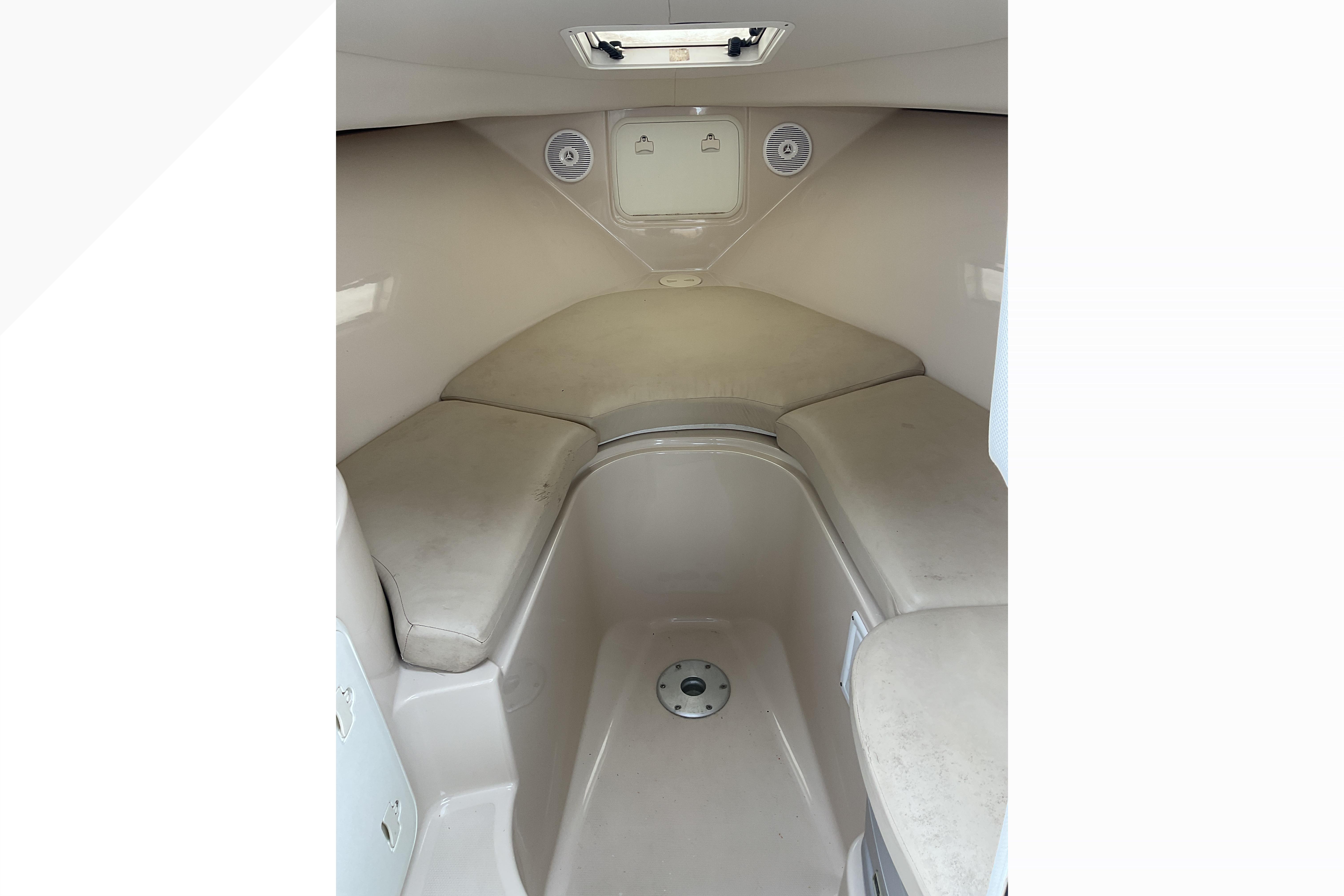 2012 Wellcraft 232 Coastal cabin interior with cushioned seating and storage compartments.