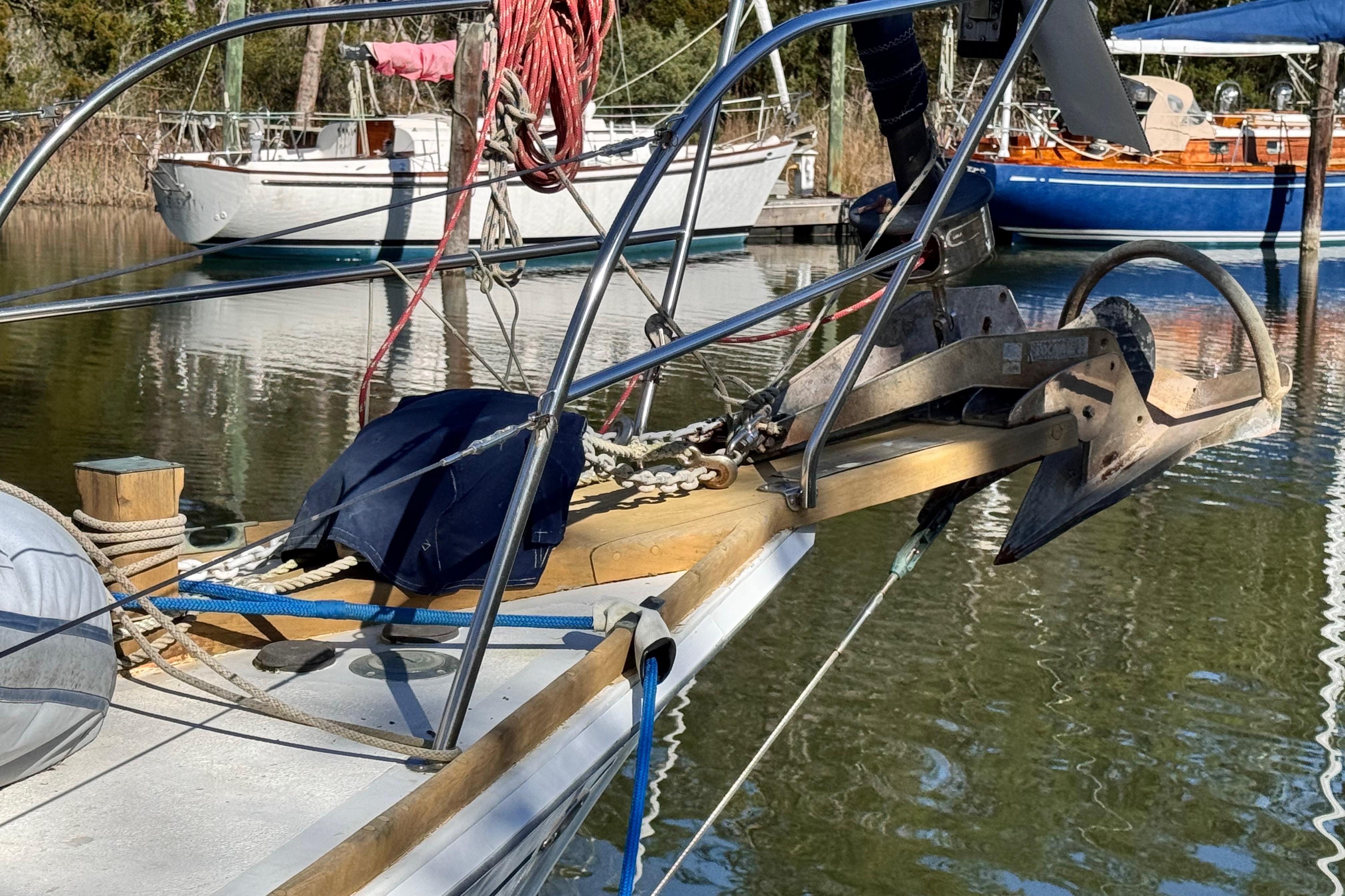 1980 Dickerson Center Cockpit Ketch with anchor, docked in a serene marina setting.