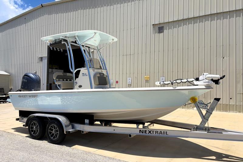 2025 Key West 210 Bay Reef boat on trailer outside a large building.