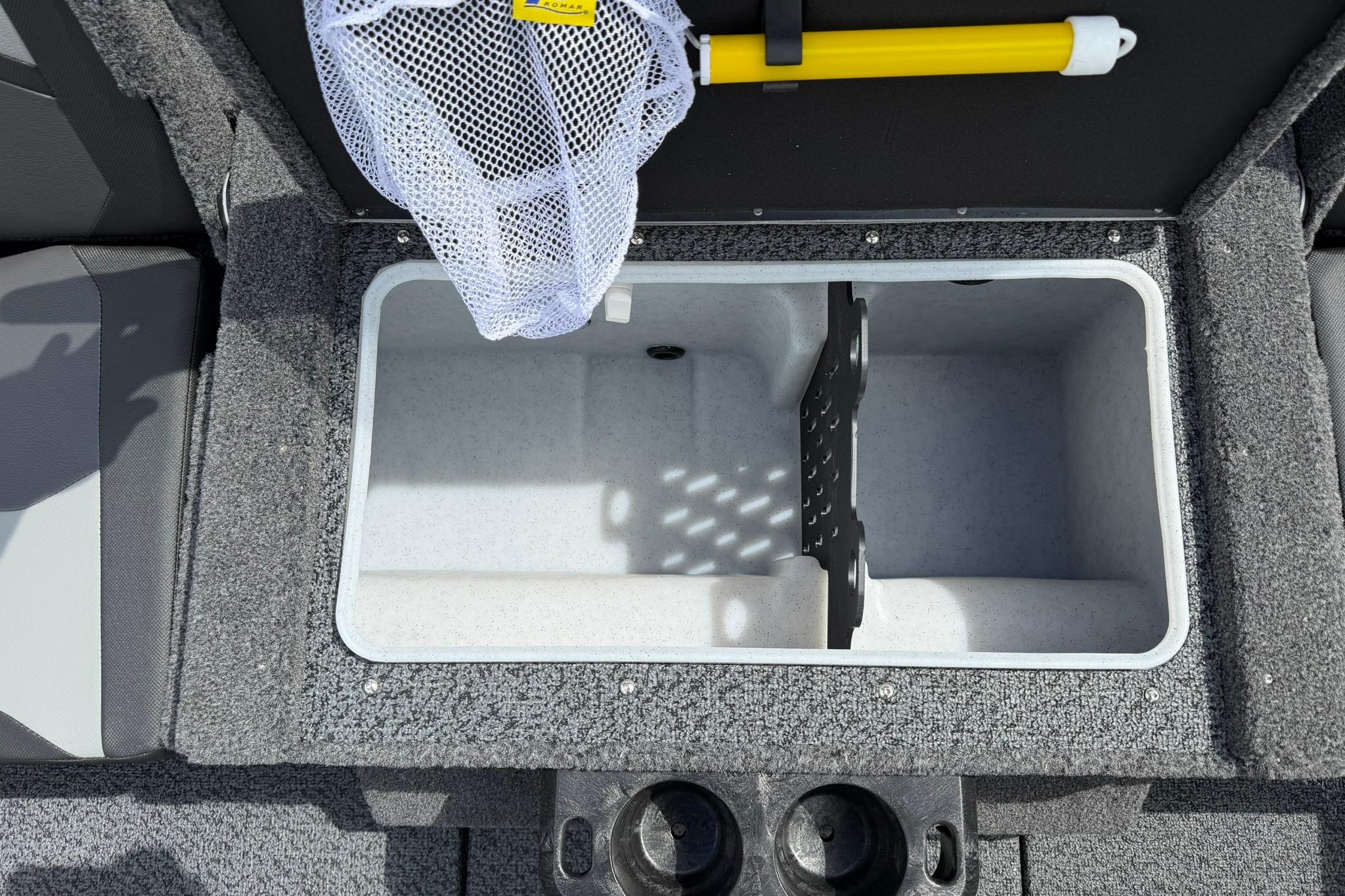 Interior storage compartment of 2027 Lund 1875 Crossover XS boat with net and yellow handle.