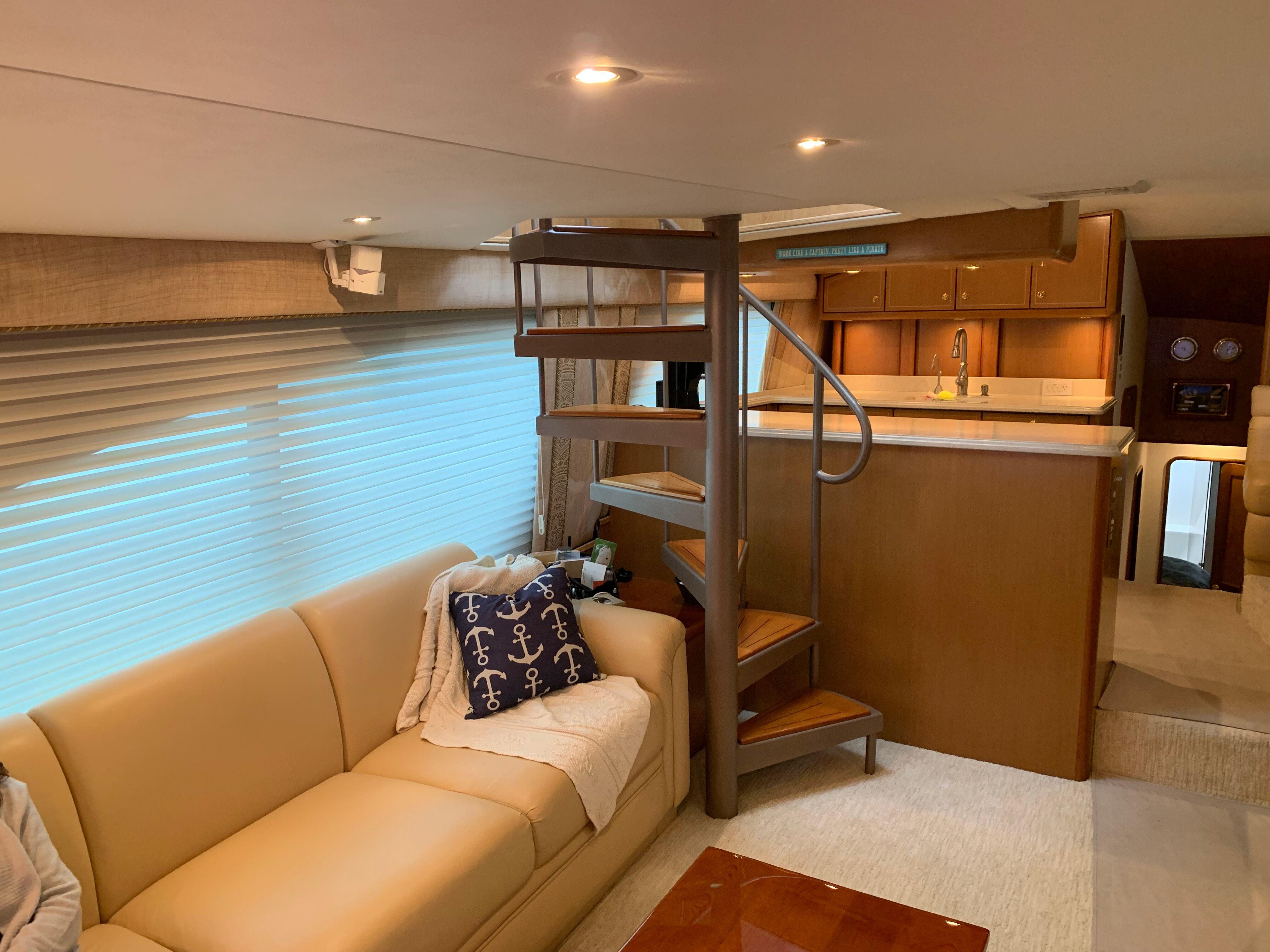 Luxurious interior of 2004 Ocean Yachts 57 Odyssey with spiral staircase and cozy seating area.