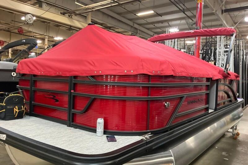 2026 Bennington 22 SSRSF pontoon boat with red cover in a warehouse setting.