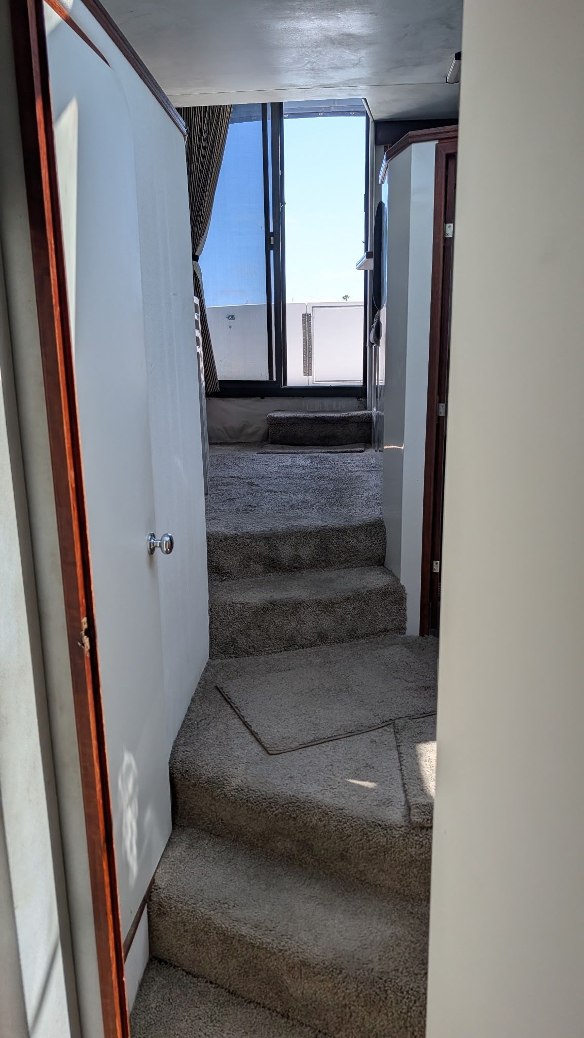 Interior of a 1987 Chris-Craft 320 Amerosport Express with carpeted stairs and a door.