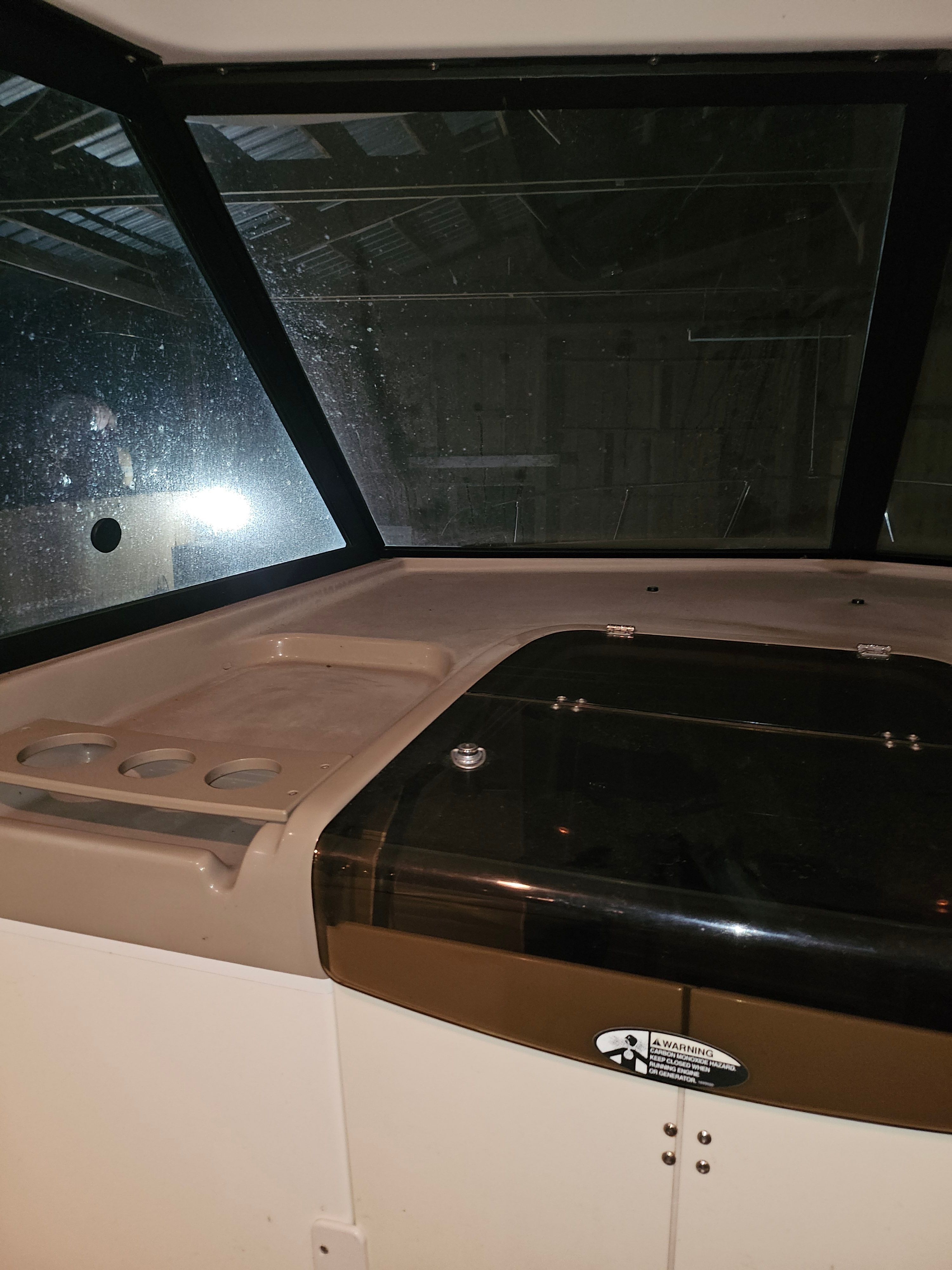 The image shows the cockpit of a 2005 Bayliner 242 Ceara with a dark dashboard.