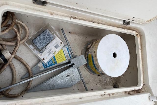 Storage compartment of 2001 Fountain 38 Center Console with anchor and rope.
