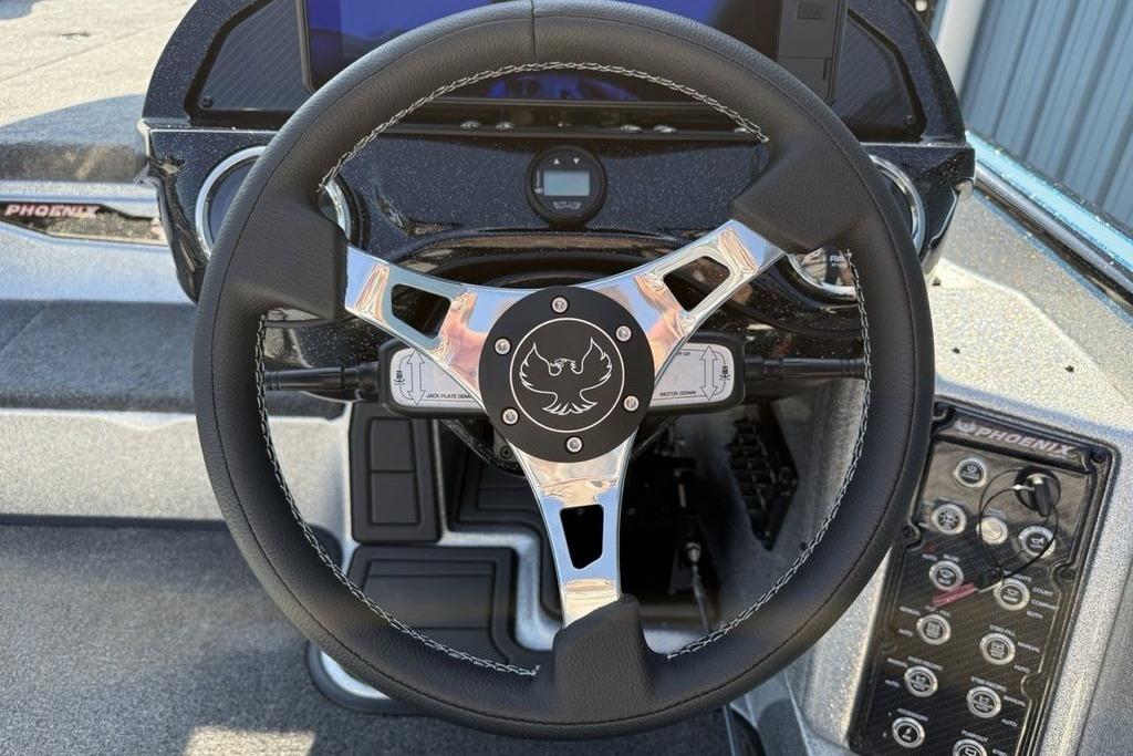 Steering wheel of 2026 Phoenix 20 XE boat with control panel and logo.