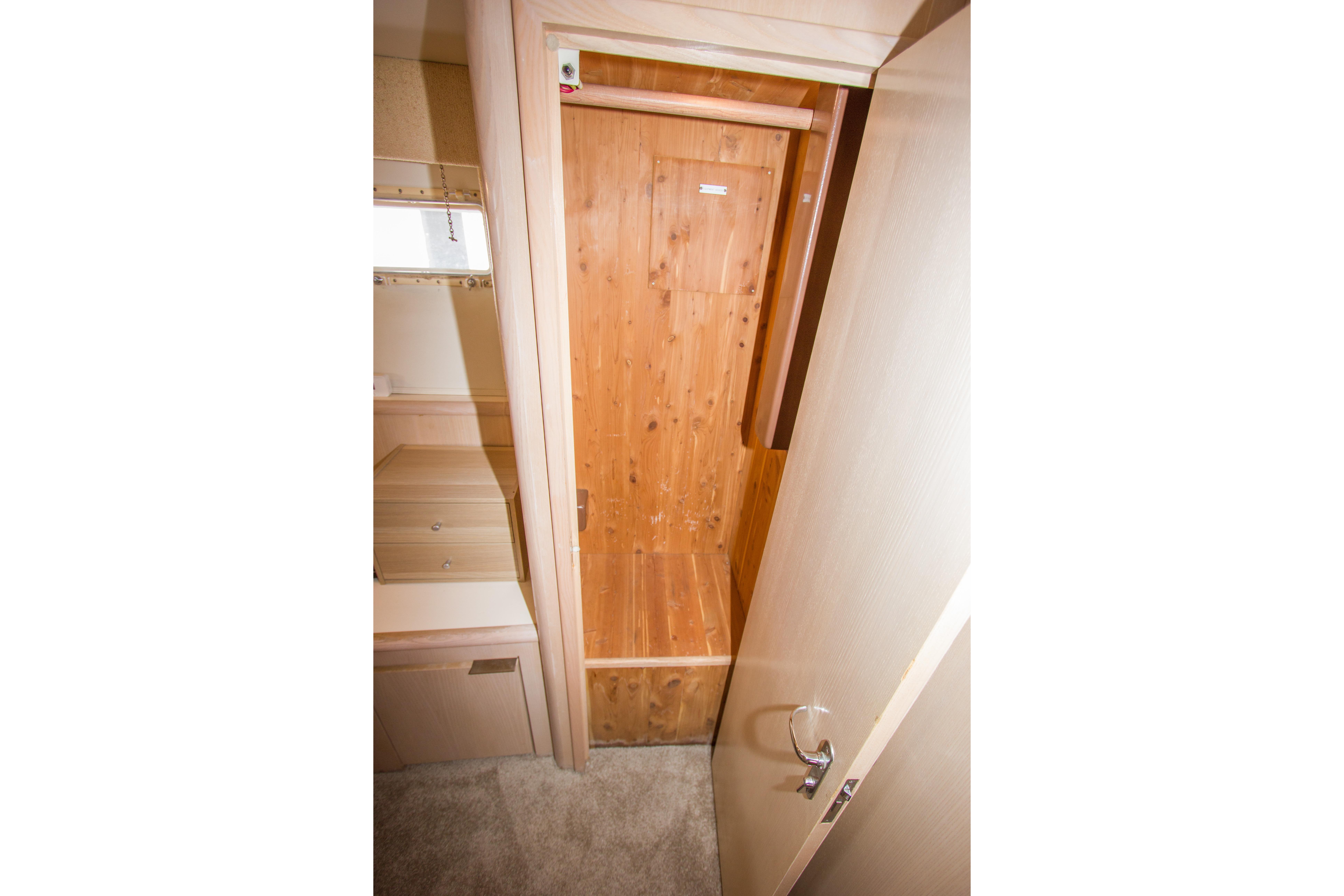 Interior view of a 1994 Hatteras 52 Cockpit Motor Yacht closet with wooden finish.