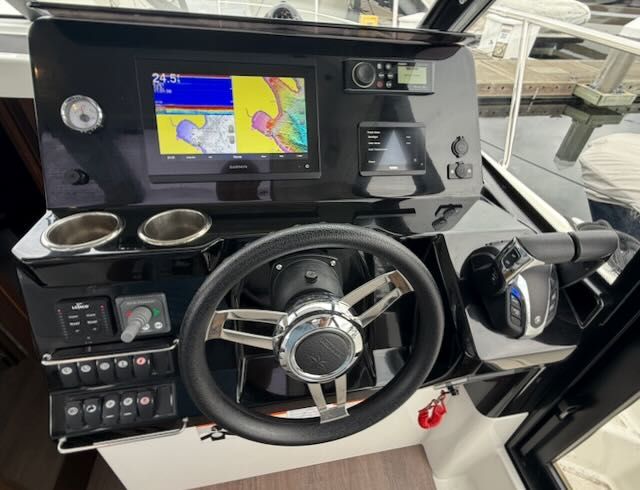 The image shows the helm of a 2021 Jeanneau NC 1095 with modern navigation instruments.