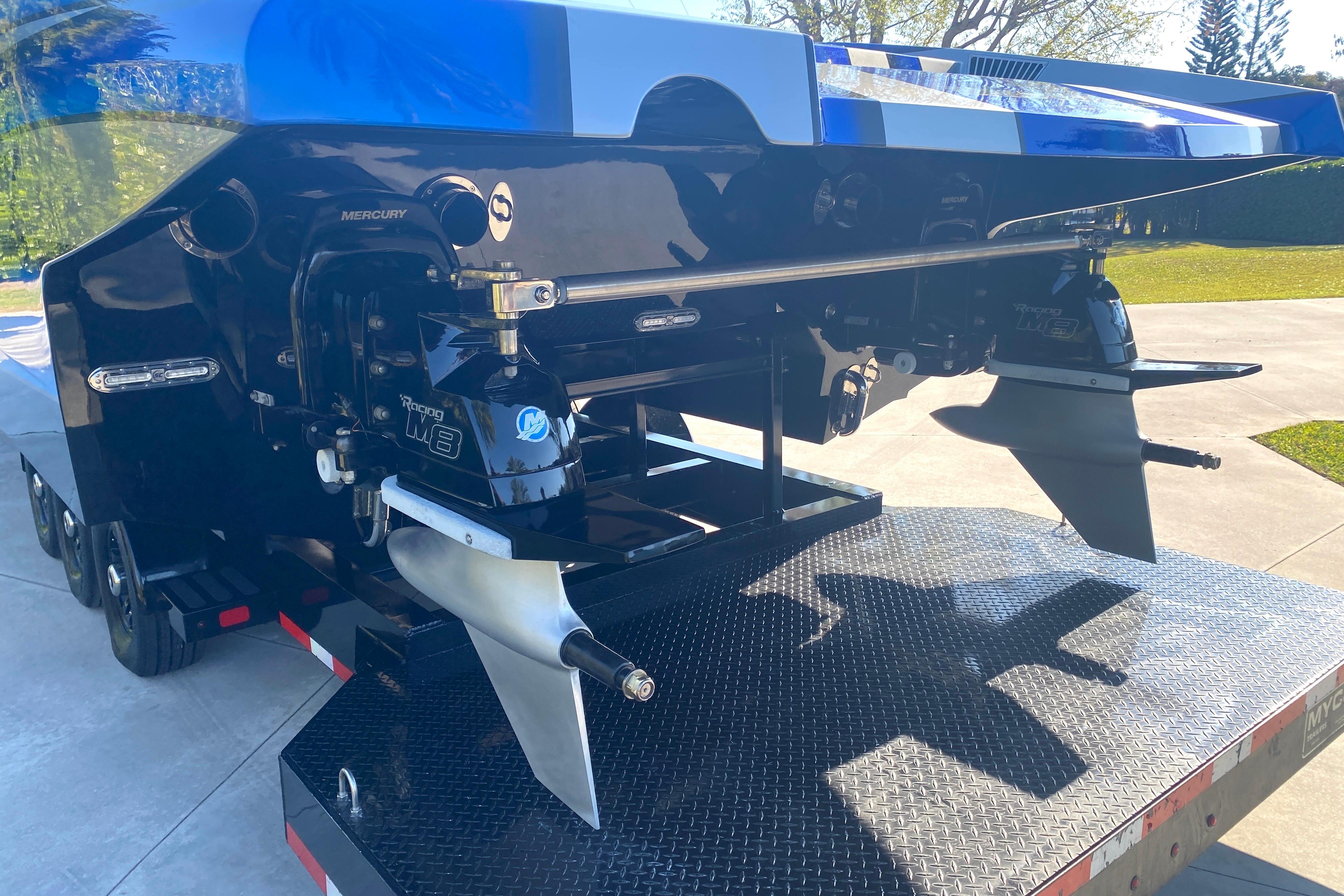 Rear view of a 2016 MTI 44 RP boat on a trailer, showcasing Mercury engines.