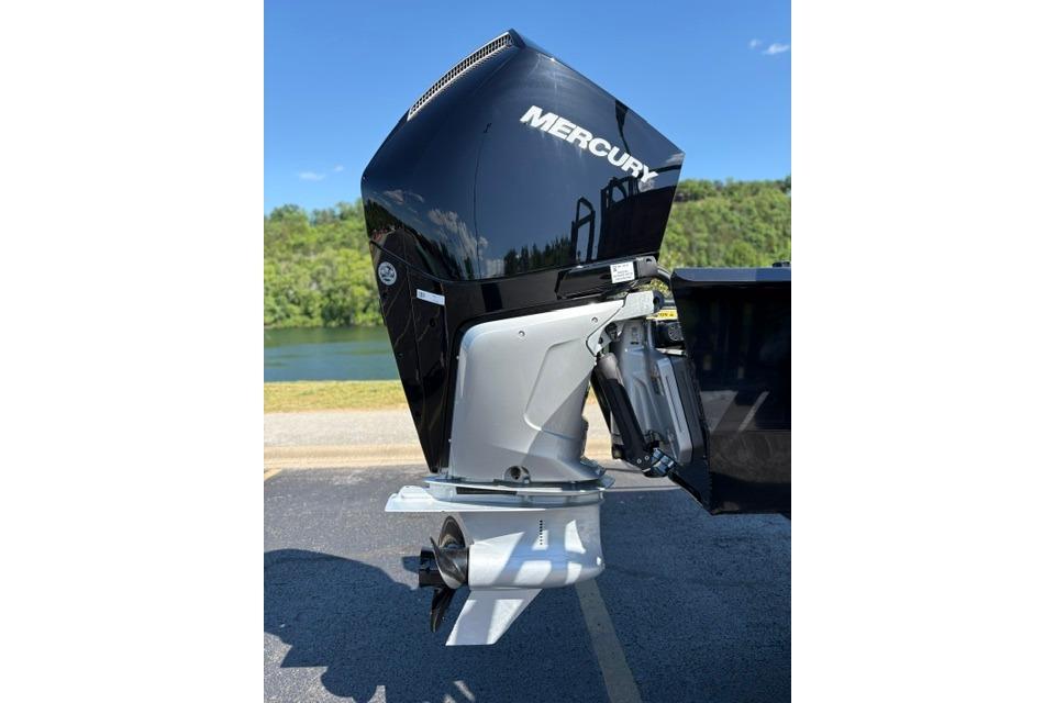 2025 Regency 250 DL3 boat with Mercury outboard motor by a lake.