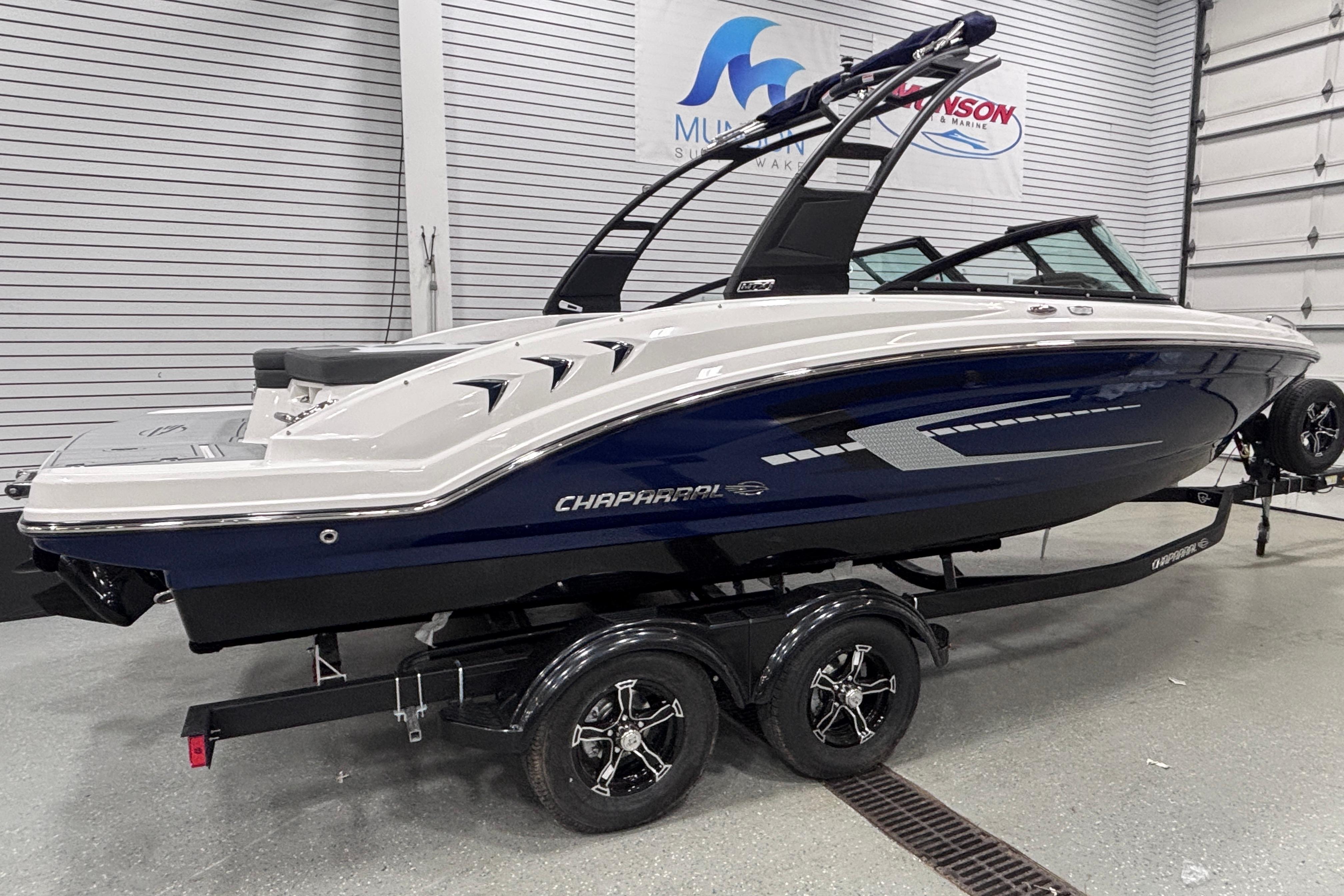 2026 Chaparral 23 SSi boat in showroom, sleek design, on trailer.