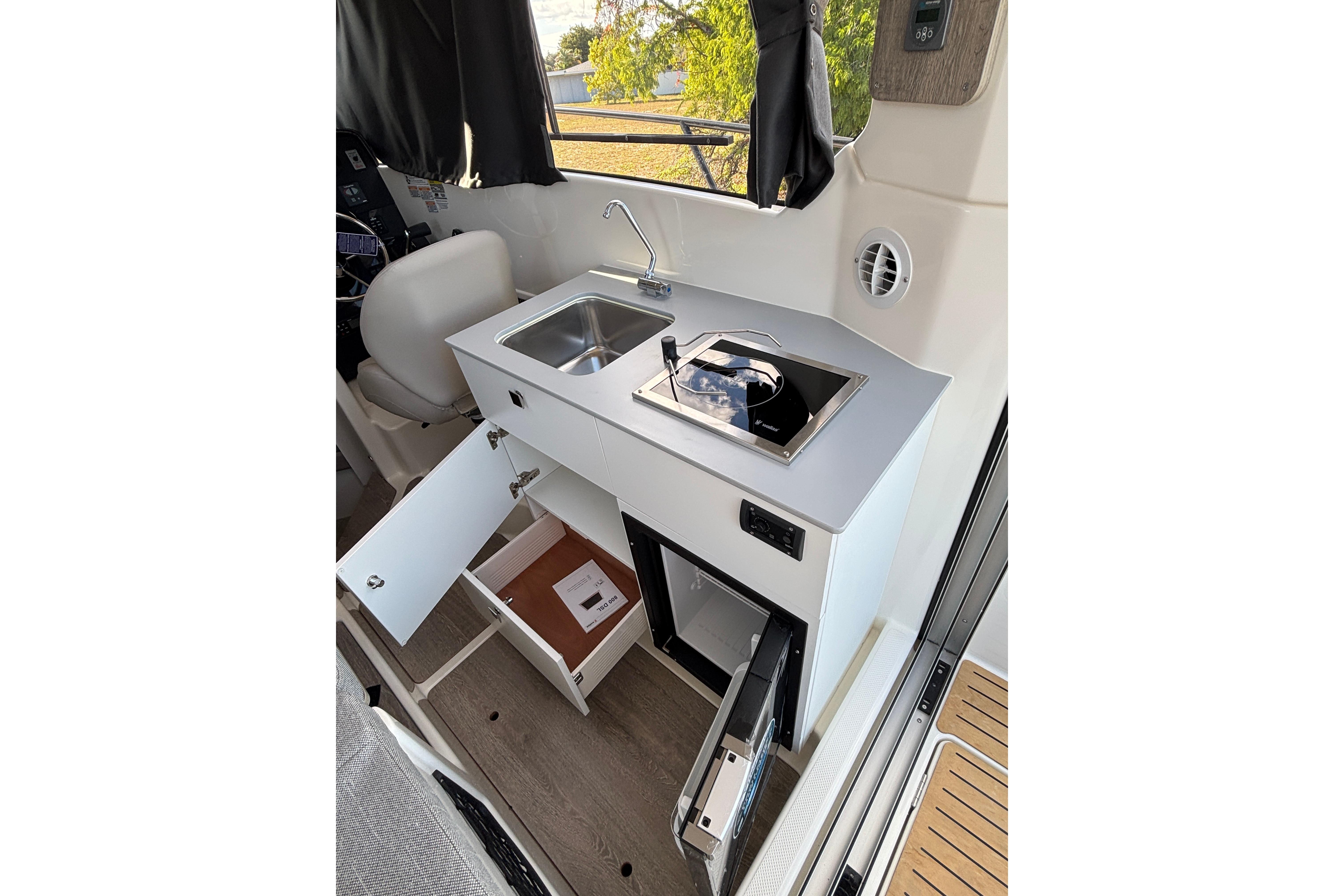 Interior of 2026 Trophy T 25 Explorer boat with kitchenette and storage.