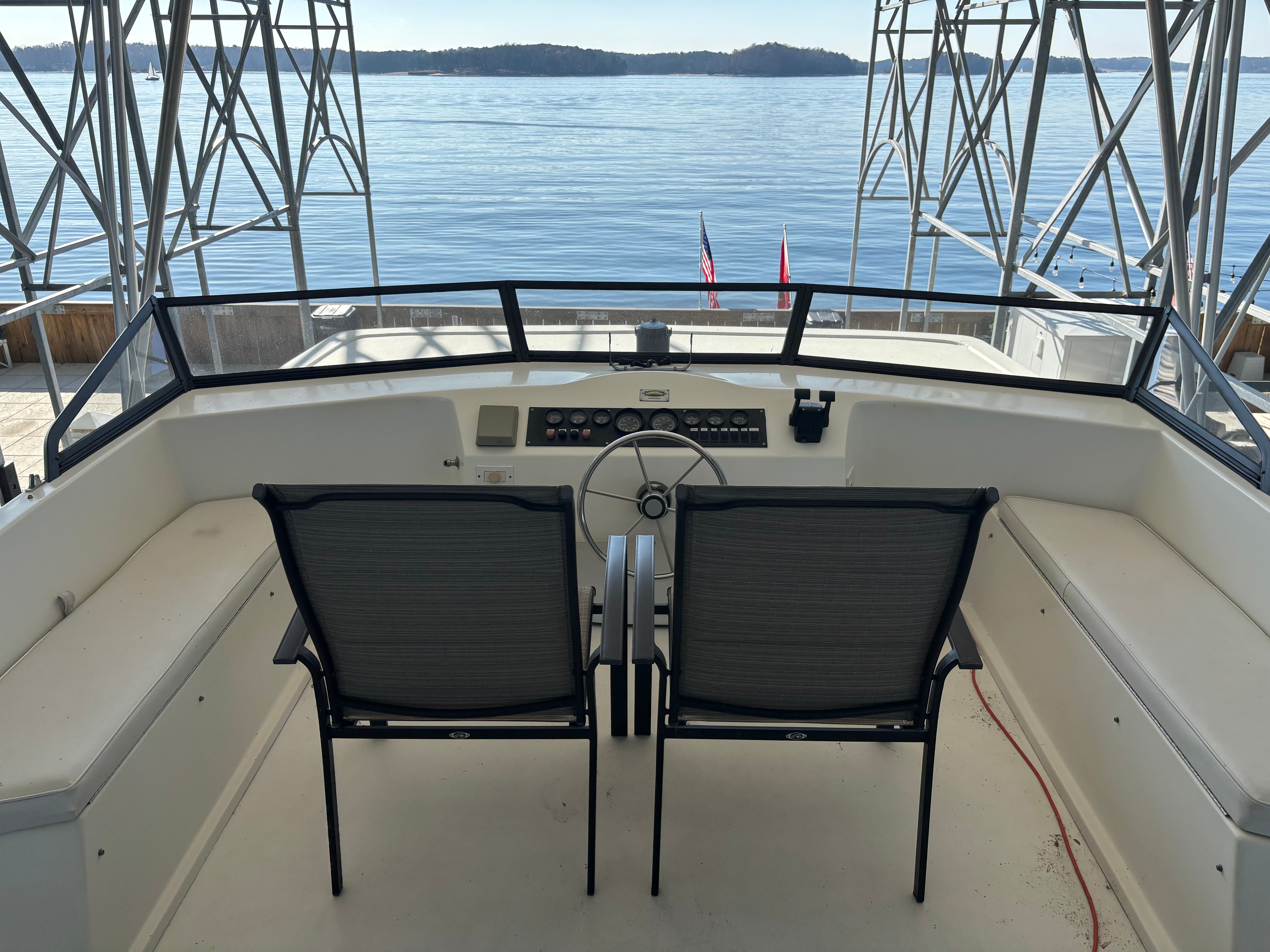 1997 Stardust Cruisers Wide Body on the water with two chairs at the helm.