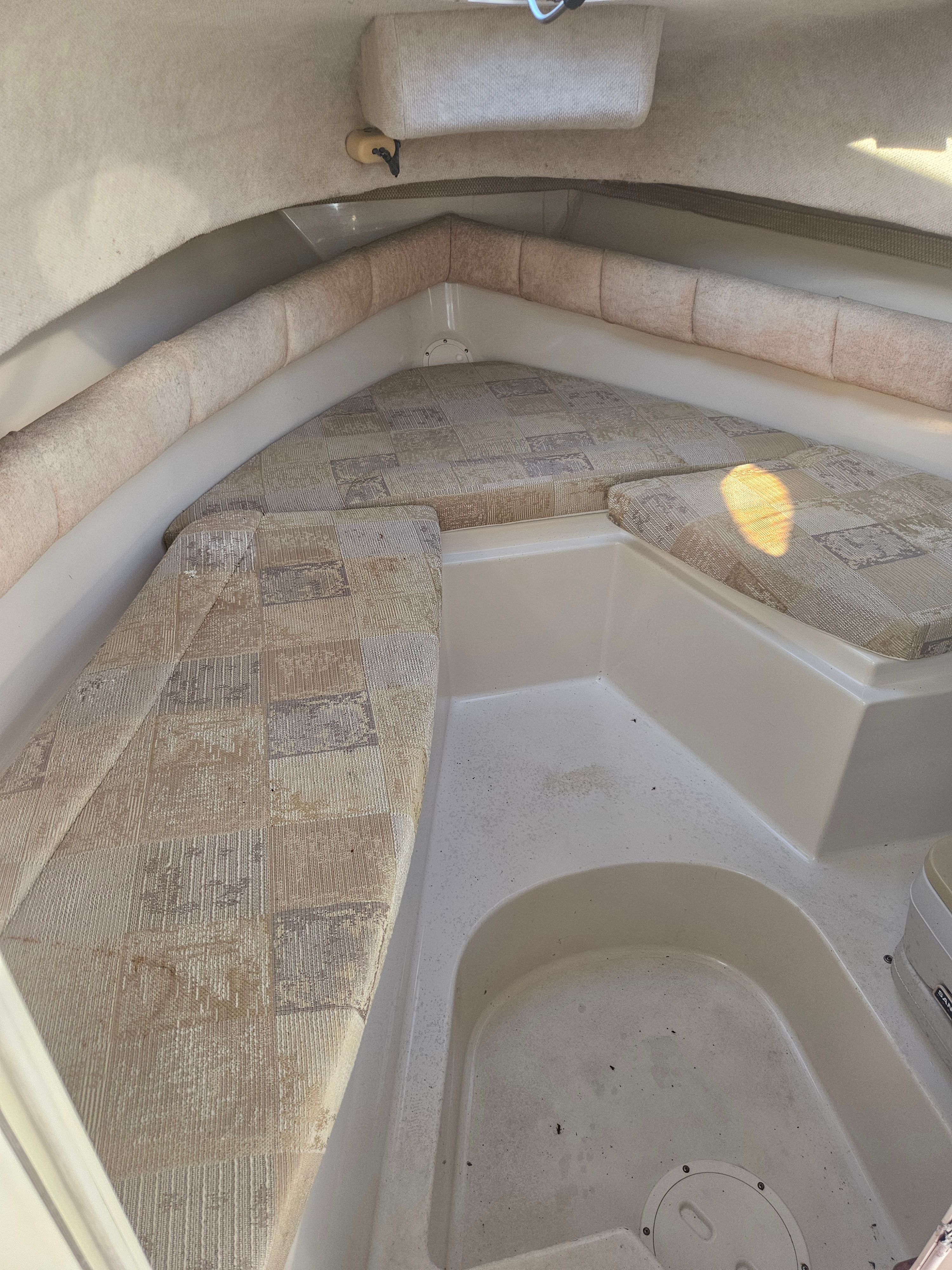 Cabin interior with cushioned seating and storage space.