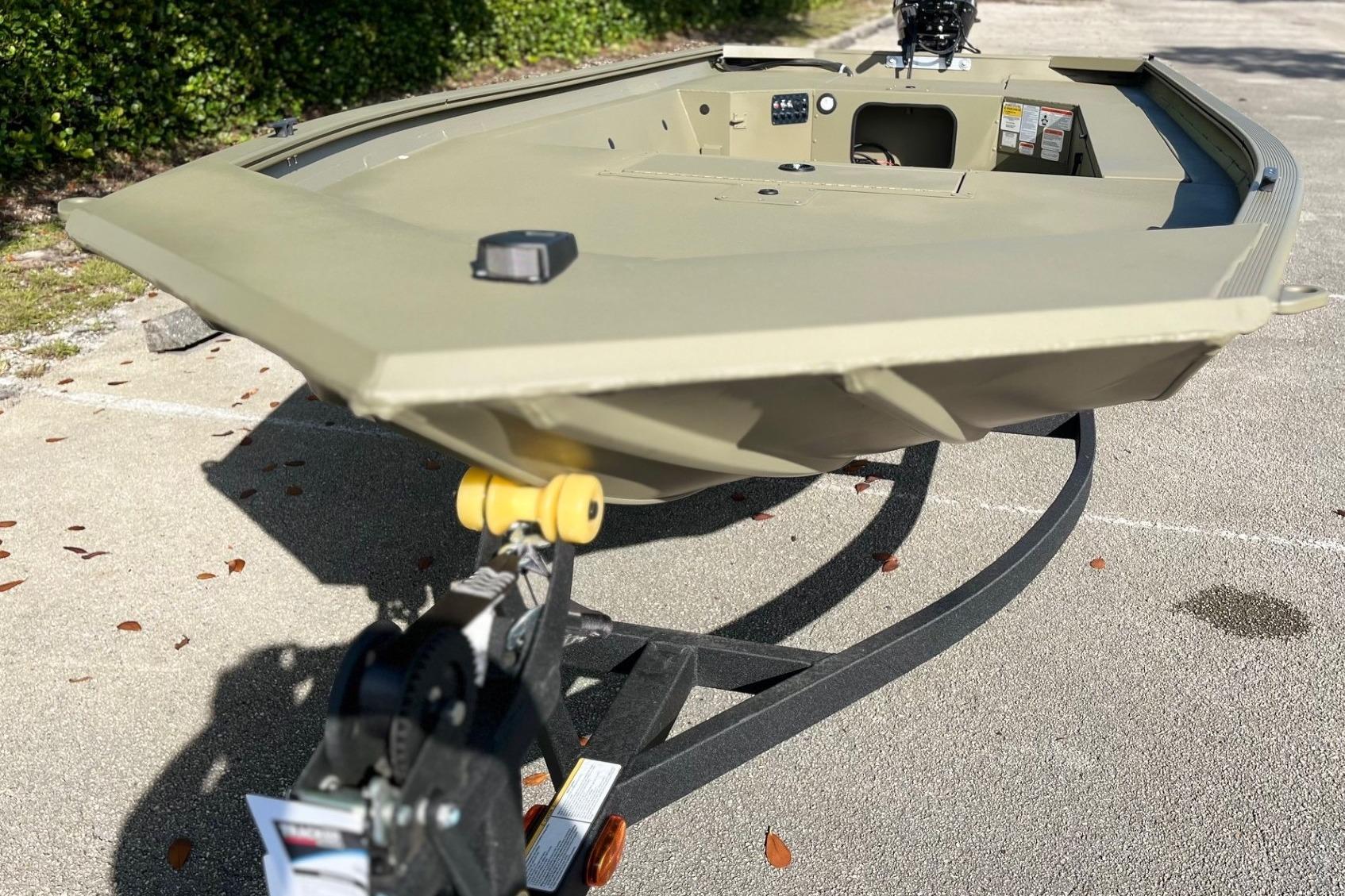 2026 Tracker Grizzly 1654 T Sportsman boat on trailer, parked outdoors.
