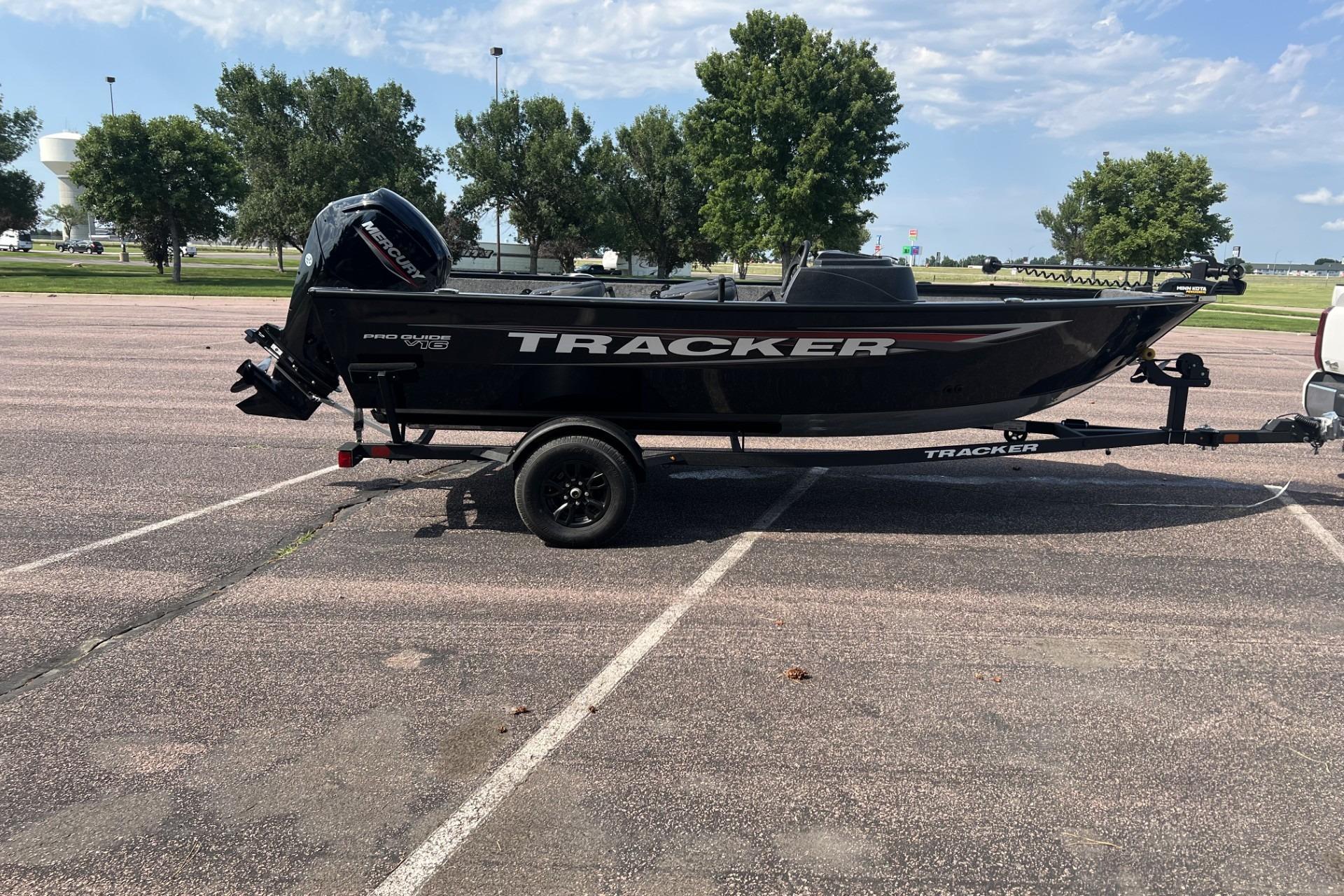 2026 Tracker Pro Guide V-16 SC boat on trailer in parking lot.