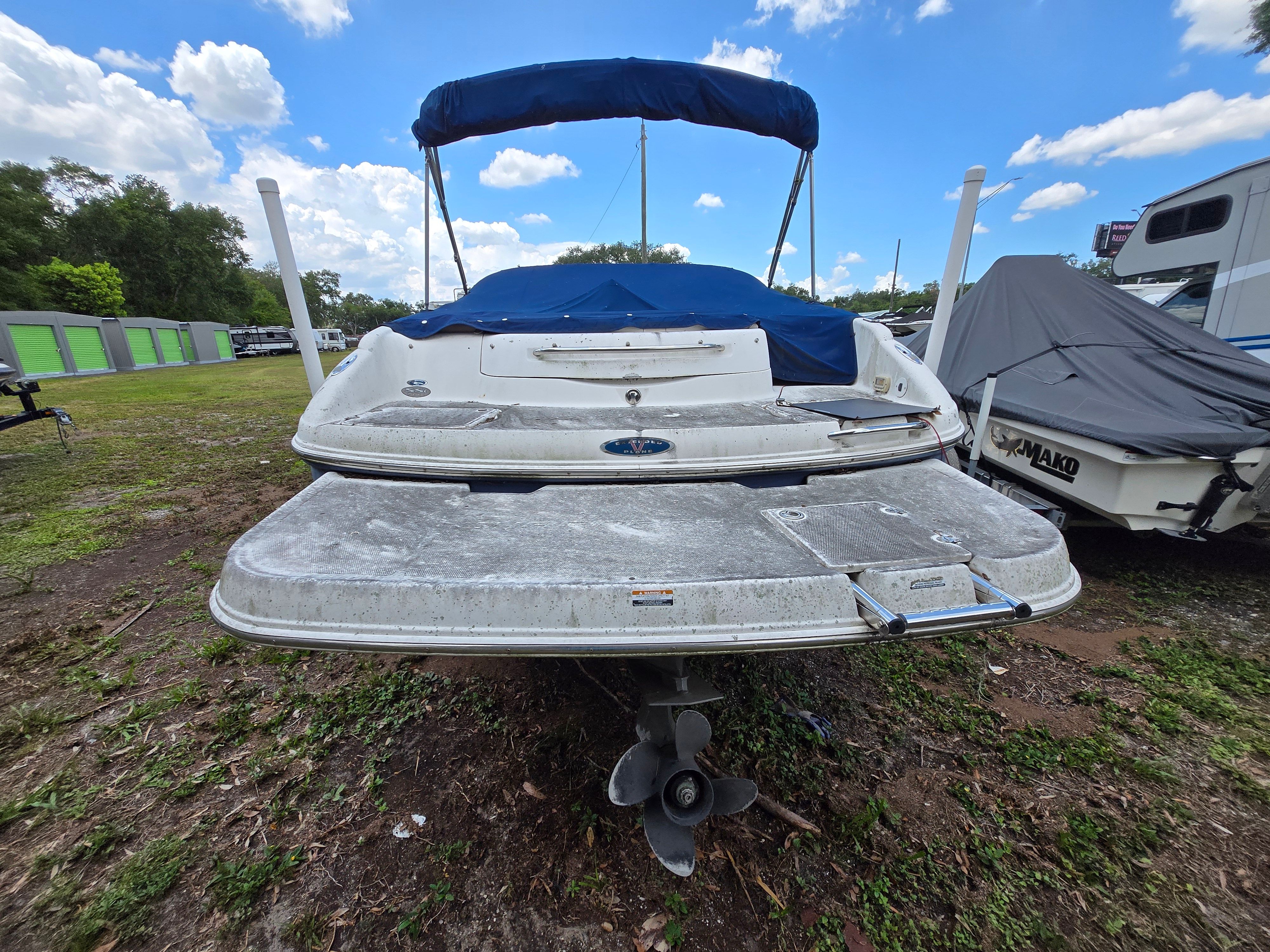 The image shows the rear of a 2006 Chaparral 220 SSi boat with a blue canopy.