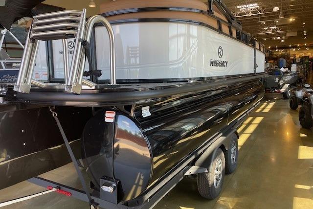 2026 Regency 230 DL pontoon boat on trailer in showroom.