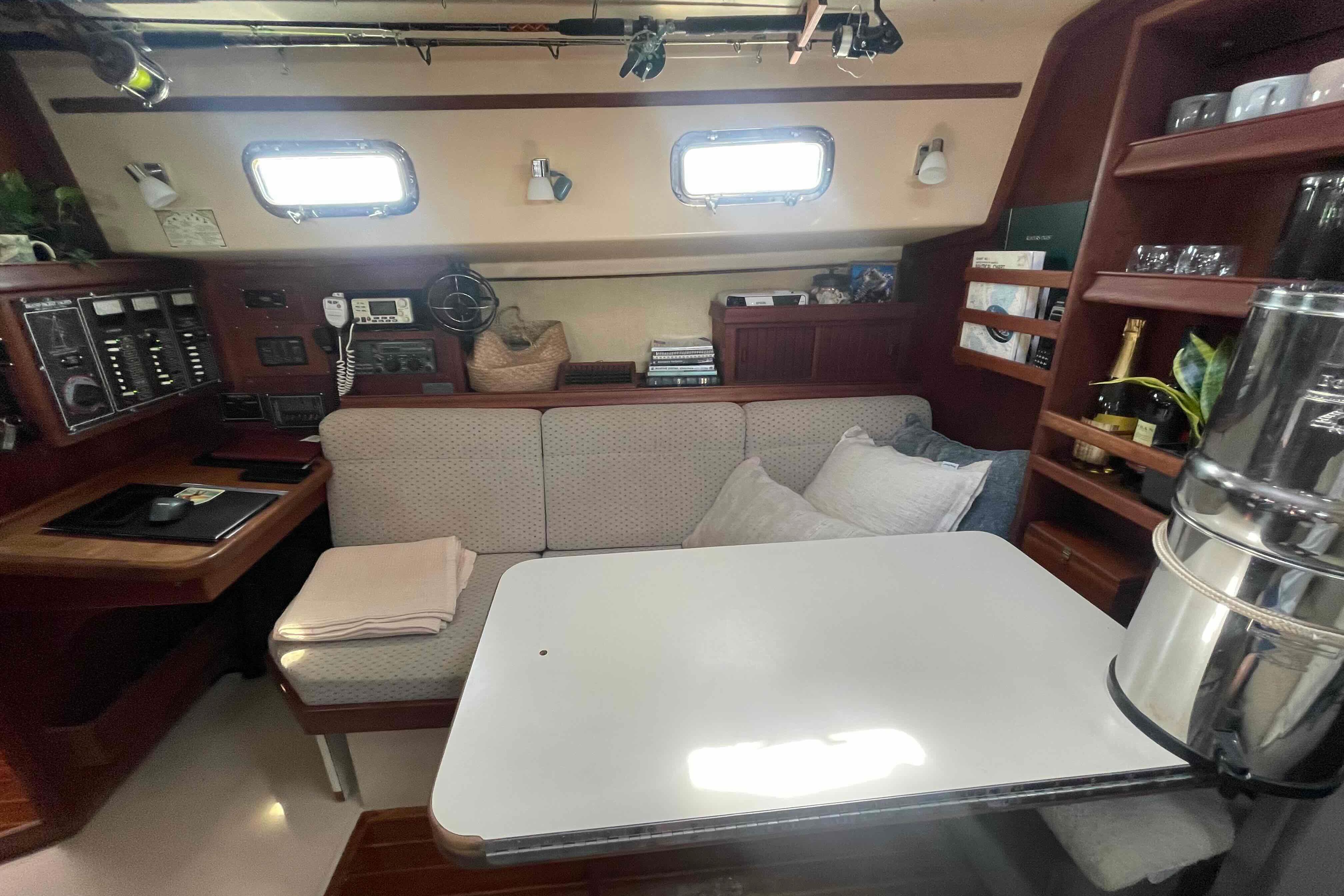 Interior of a 1989 Island Packet 35 sailboat with cozy seating and navigation equipment.