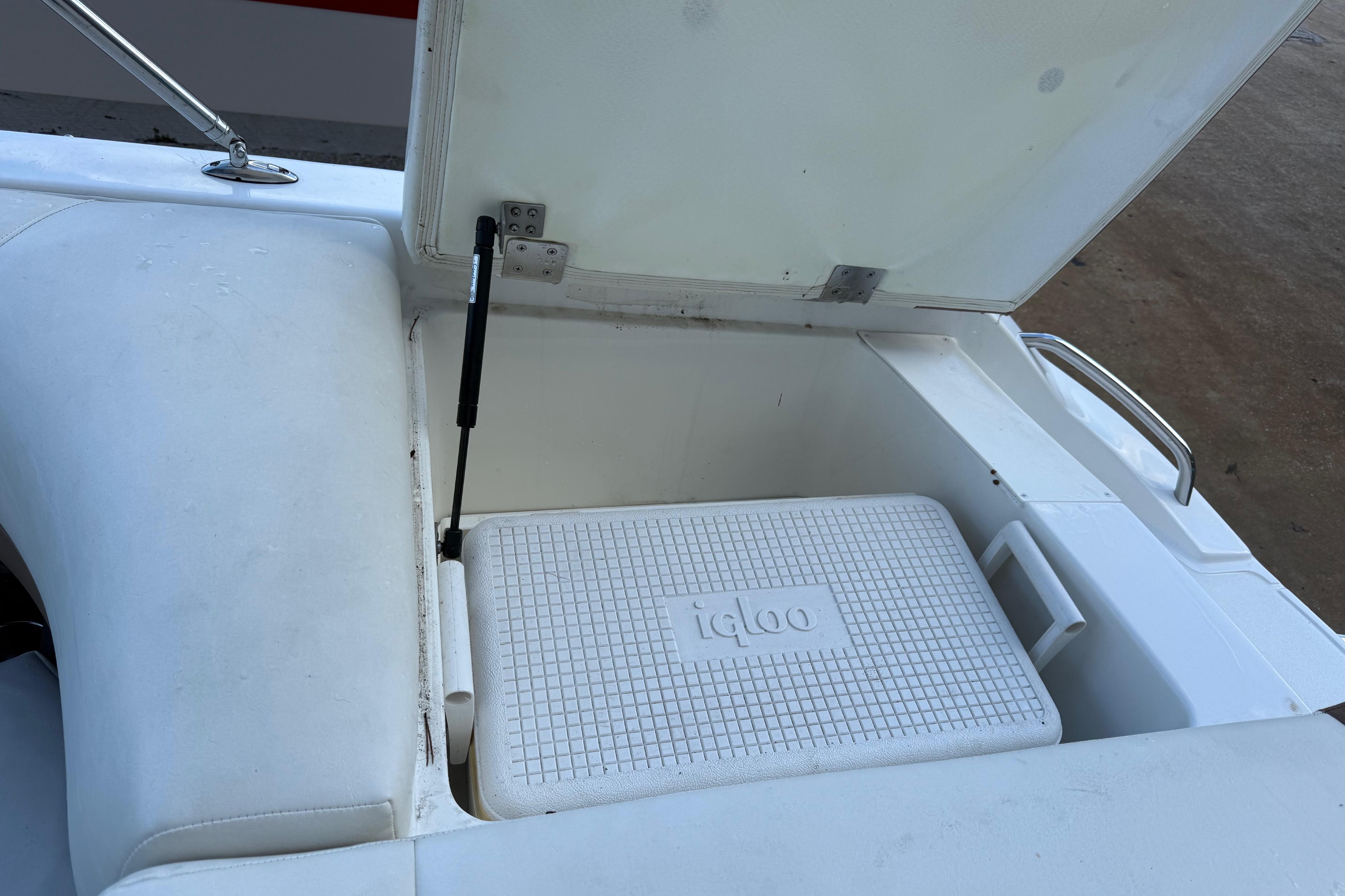 Open storage compartment on a 2015 Cobalt 200 boat with an Igloo cooler inside.