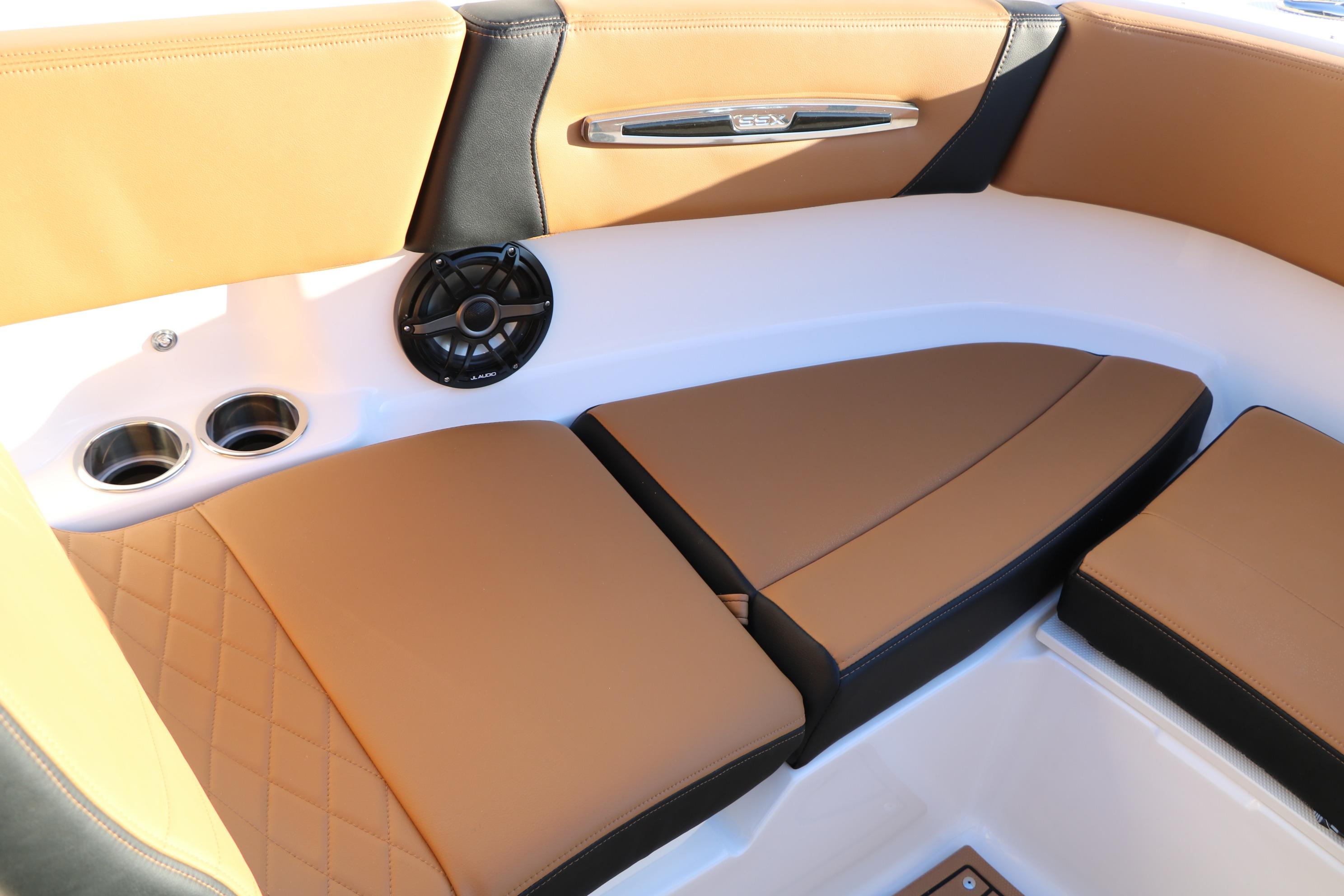 Luxurious interior of 2026 Chaparral 247 SSX boat with tan seating and speaker system.