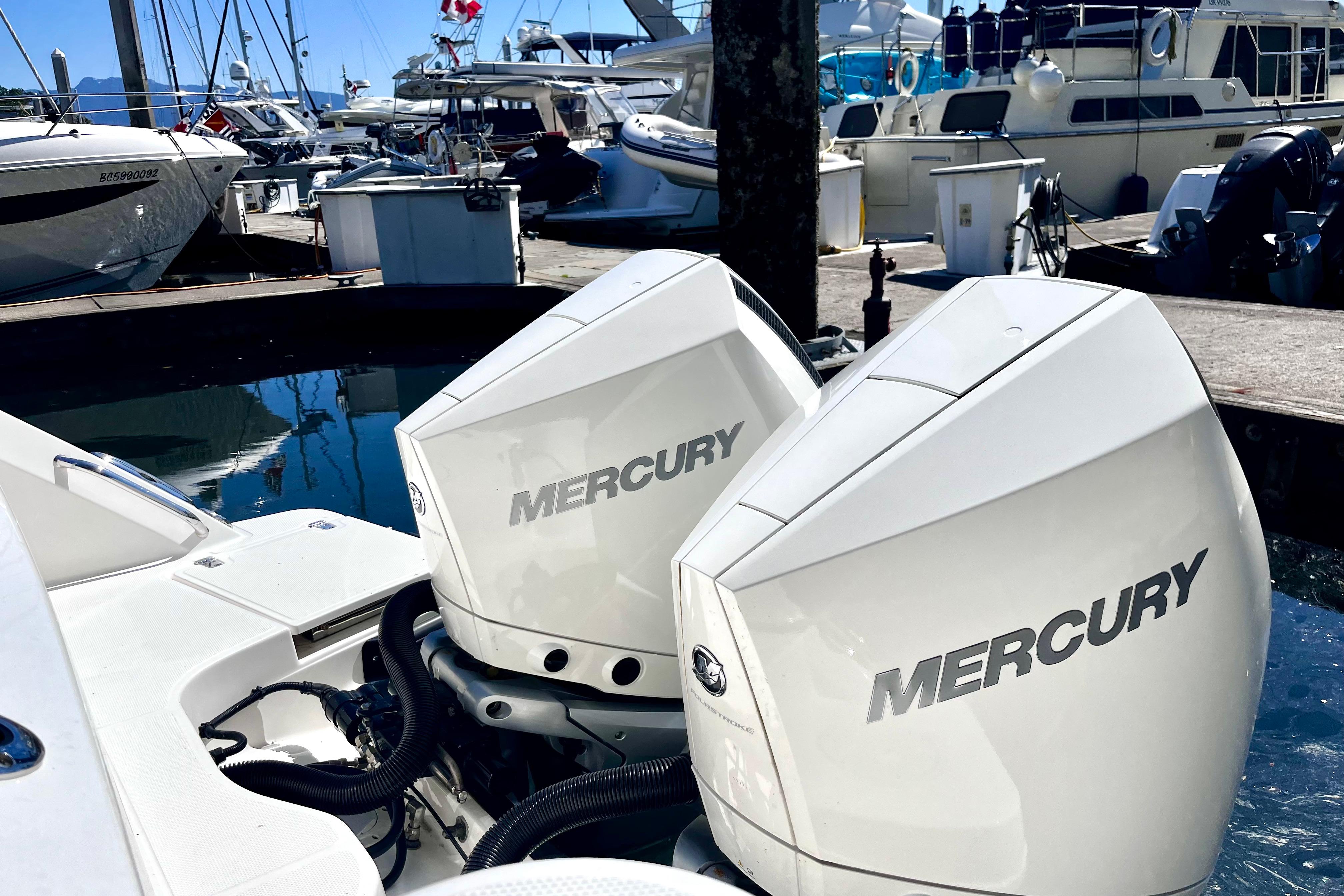 Twin Mercury outboard engines on a 2026 Boston Whaler 325 Conquest Pilothouse at a marina.