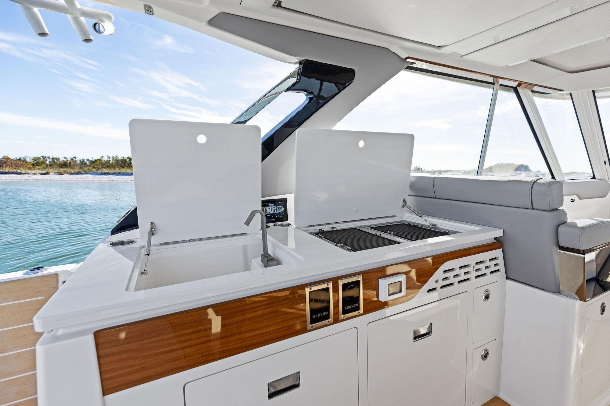 Luxurious 2026 Regal LX43 yacht interior with modern kitchenette and scenic ocean view.