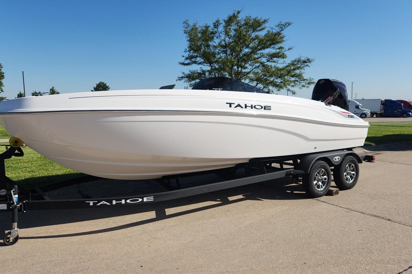 2026 Tahoe T21 boat on trailer, parked outdoors under clear blue sky.