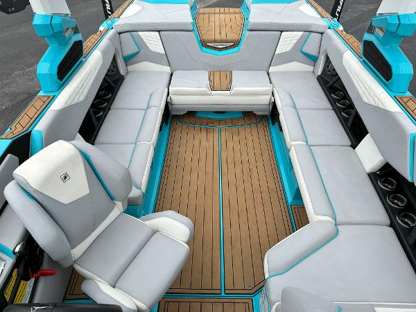 2022 Nautique S23 boat interior with gray and teal seating, teak flooring.